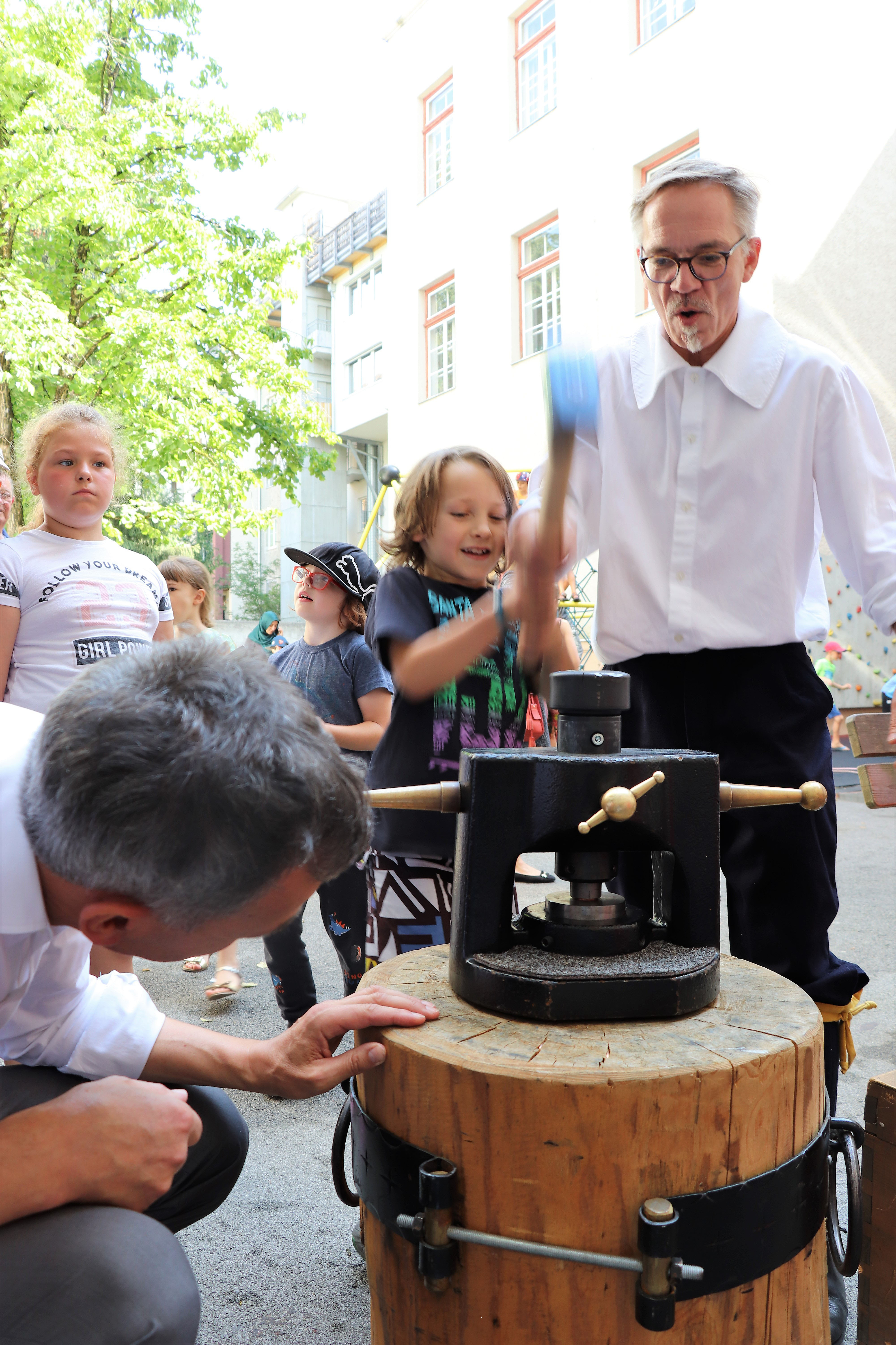 Am 1. Juli begrüßten die SchülerInnen der Volksschule Franz-Fischer-Straße Bürgermeister Georg Willi bei ihrem Sommerfest mit Spielen aus alter Zeit. Nicht nur die Kinder, auch der Bürgermeister waren trotz Hitze mit Feuereifer bei der Sache.