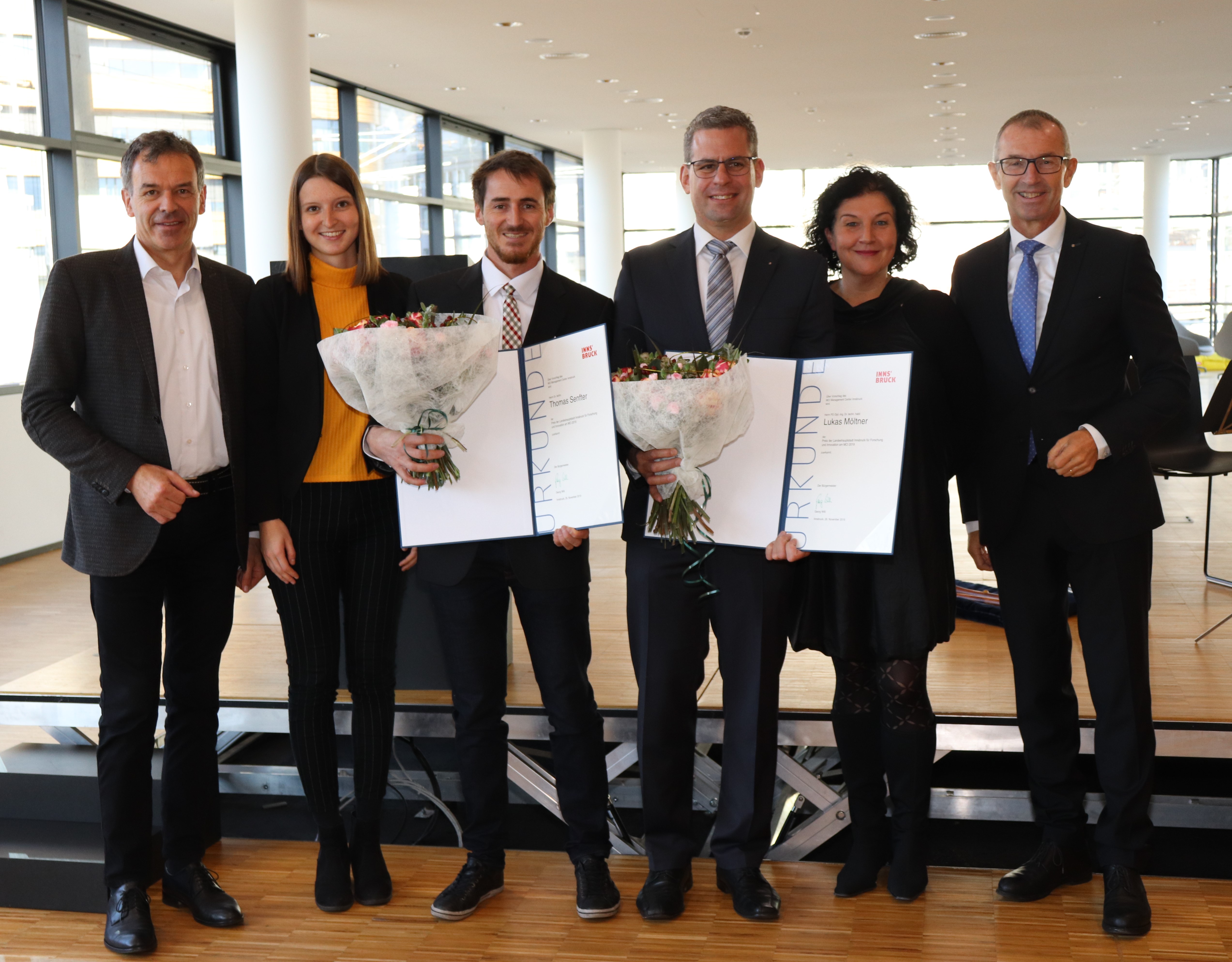 Lukas Möltner und Thomas Senfter nahmen den „Preis der Landeshauptstadt Innsbruck für Forschung und Innovation am Management Center Innsbruck (MCI) 2019“ entgegen: Bürgermeister Georg Willi (1. v.l.) und MCI-Rektor Andreas Altmann (1. v.r.), mit den Gemeinderätinnen Theresa Ringler (li.) und Irene Heisz (re.).