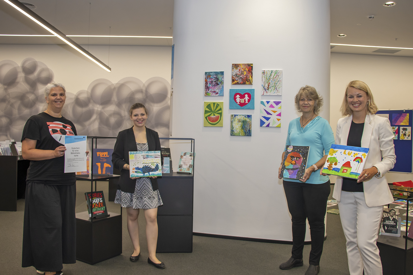 Christina Krenmayr (Leiterin der Stadtbibliothek), Alicia Martin-Gomez, Karin Martin-Gomez (Kinderfreunde Tirol) und Stadträtin Elisabeth Mayr (v. l.) zeigen sich von den Kunstwerken begeistert.