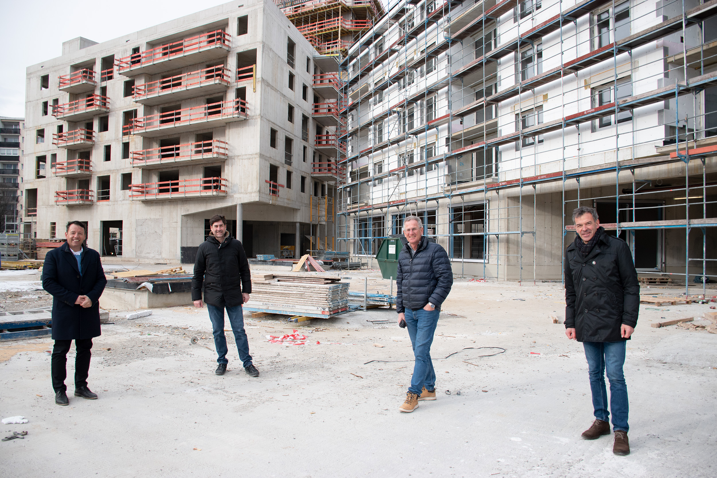 Bürgermeister Georg Willi und IIG-Geschäftsführer Franz Danler mit den beiden verantwortlichen Bauleitern der IIG, Stefan Pammer (links) und Klaus Reitmeir vor einem der großen Wohnbauprojekte, dem Campagne-Areal in der Reichenau.