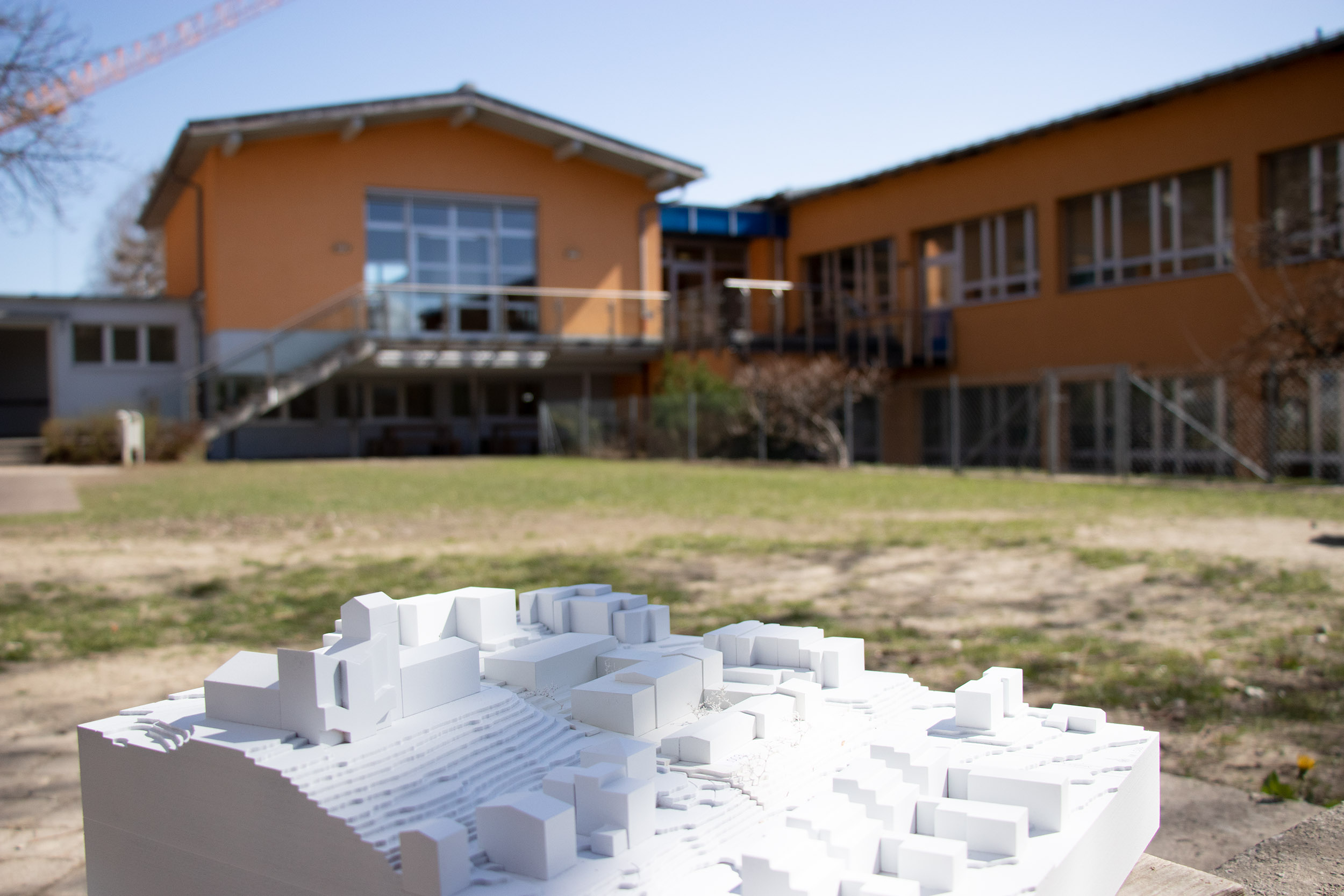 Der schlanke Zubau im Modell und real: angebaut wird an den längs verlaufenden Gebäudeteil rechts im Bild. Der Innenhof bleibt wie er ist.