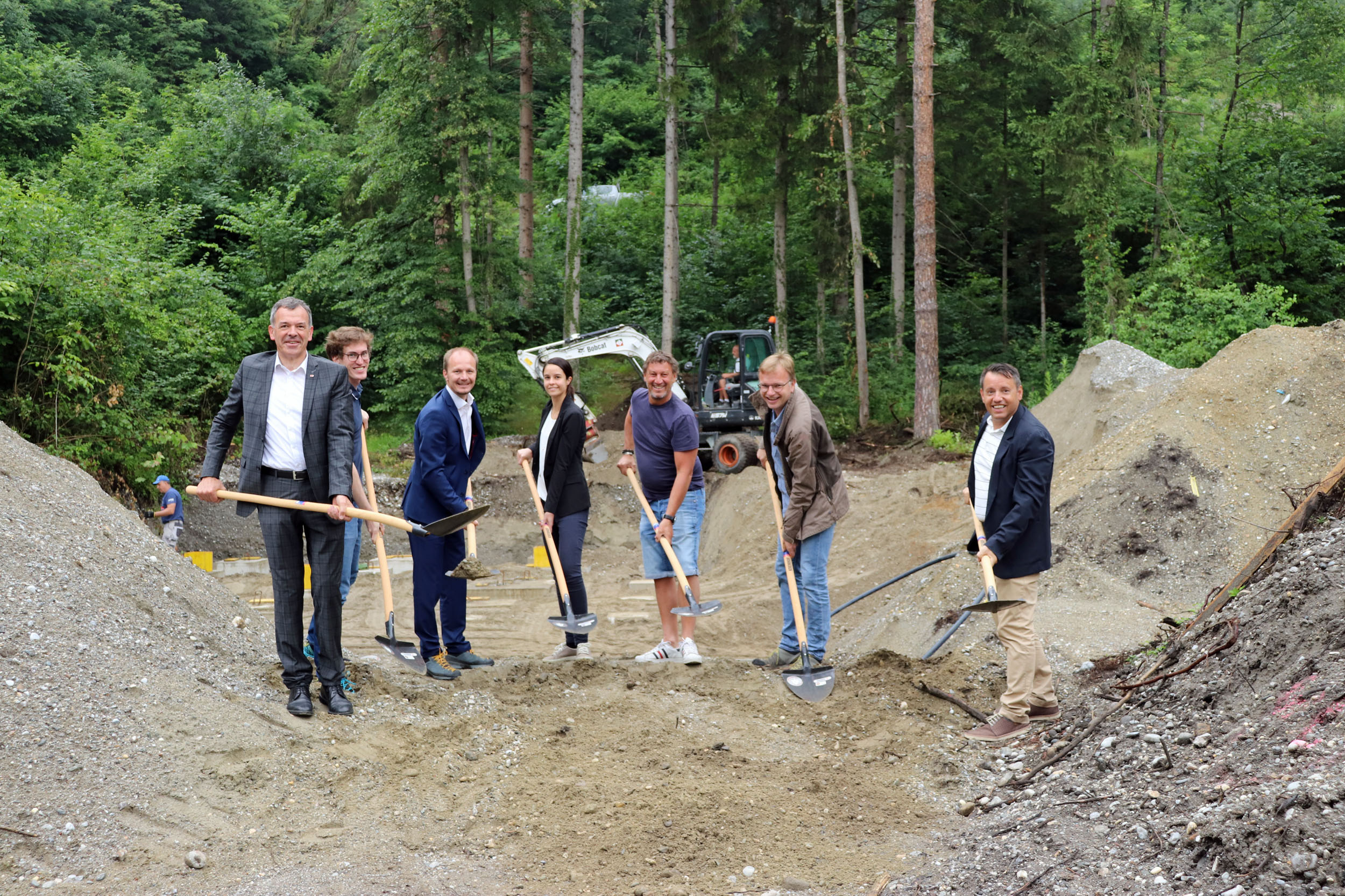 Bürgermeister Georg Willi (l.), Vizebürgermeister Johannes Anzengruber (3.v.), Albuin Neuner, Referatsleiter Natur und Erholung (2.v.r.) sowie VertreterInnen der IIG (r., GF Franz Danler) und der Baufirma Huter & Söhne freuen sich über die Fortschritte bei der Errichtung der Waldschule auf der Erlerwiese.