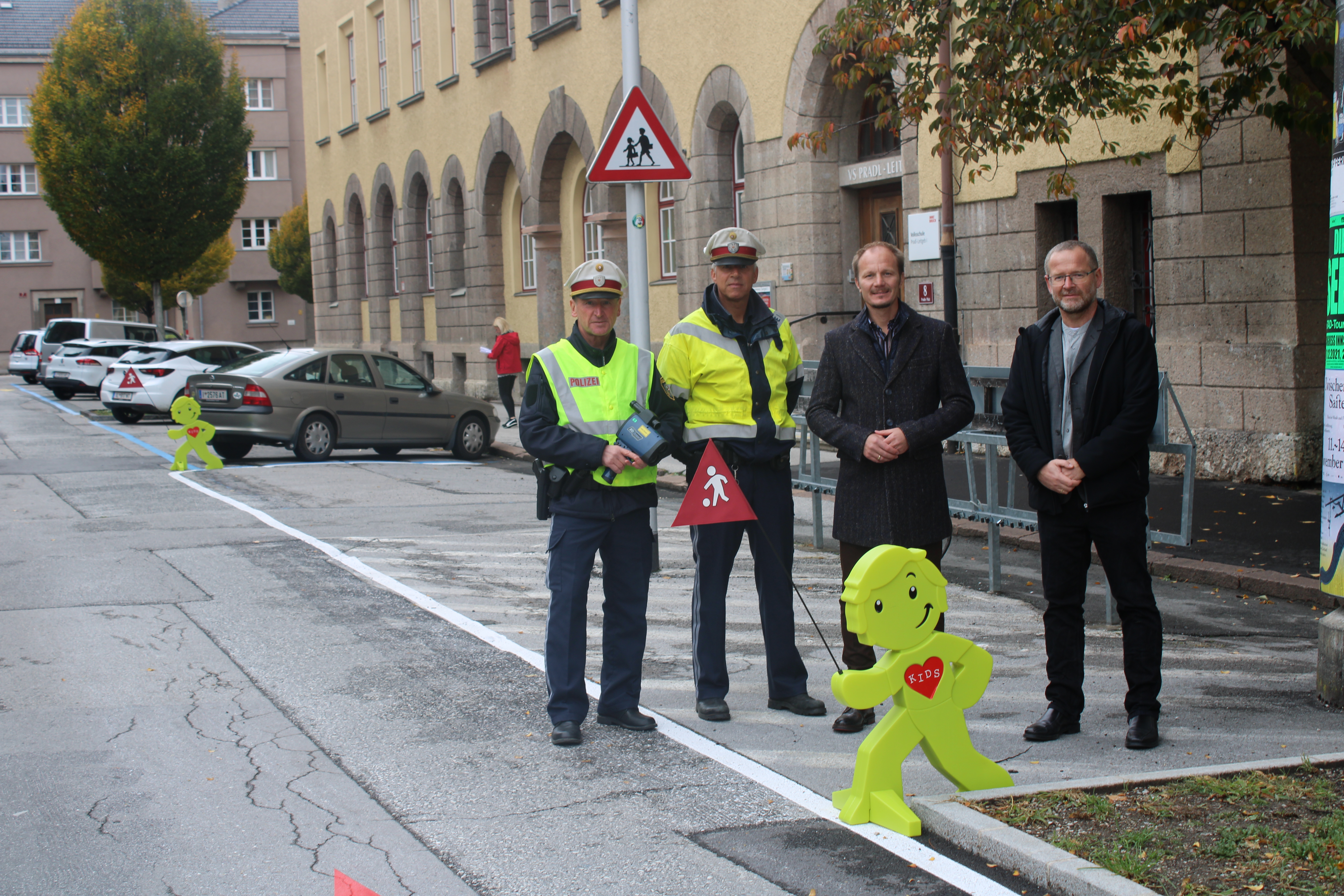 Vizebürgermeister Johannes Anzengruber, Amtsleiter Allgemeine Sicherheit, Klaus Feistmantl (r.), sowie zwei Polizisten der Verkehrsinspektion Wilten appellieren für mehr Aufmerksamkeit im Straßenverkehr. Mit den grün leuchtenden "StreetBuddies" sollen alle VerkehrsteilnehmerInnen frühzeitig darauf hingewiesen werden, dass sich wieder ab 12. September in den Bereichen der Aufsteller besonders viele Kinder auf den Weg in die Schule und den Kindergarten machen.