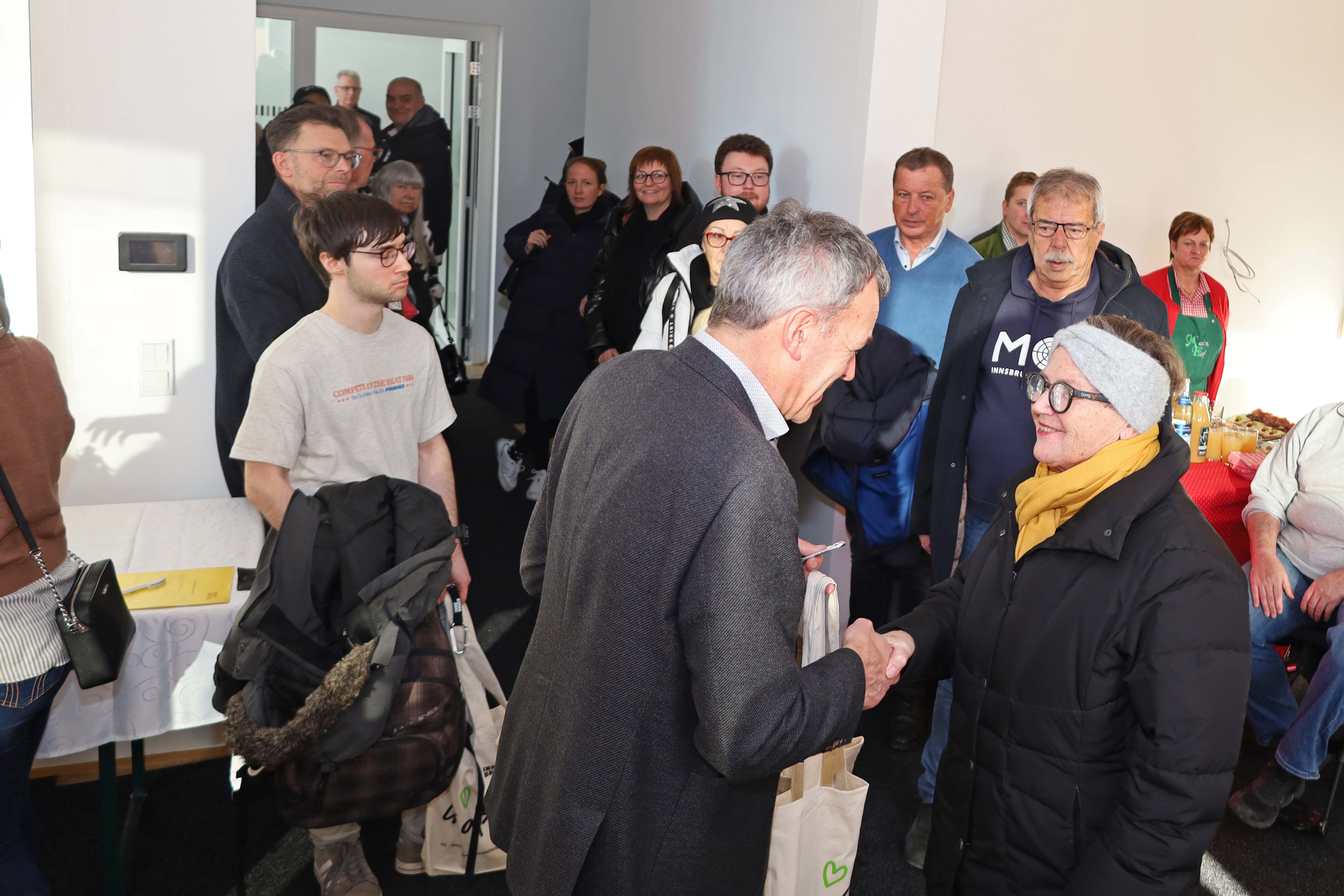 Bürgermeister Georg Willi freut sich mit der neuen Bewohnerin: Das Wohngebäude ist zudem ein Haus für alle Generationen.