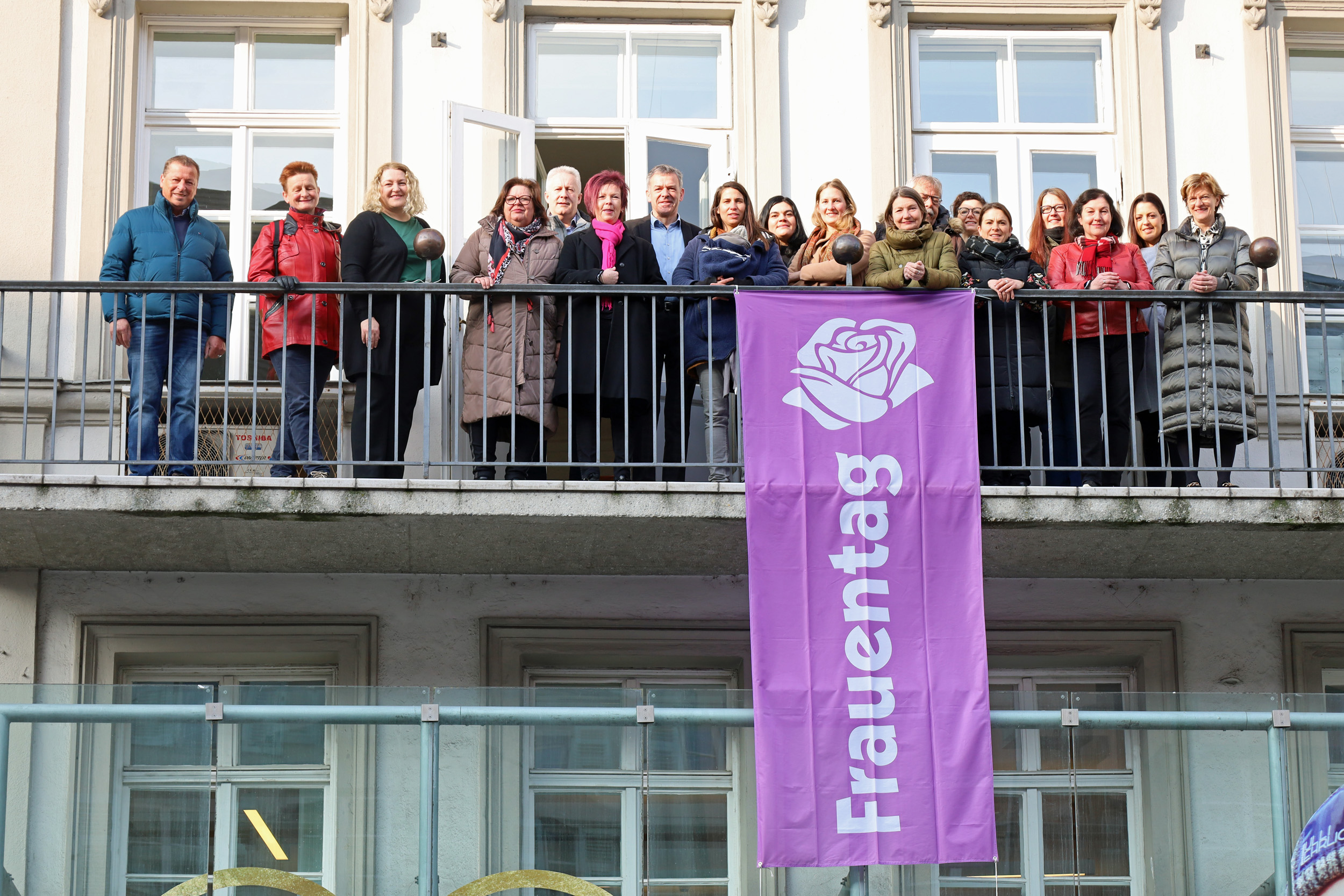 Bürgermeister Georg Willi (7. v. l.), Stadträtin Uschi Schwarzl (8. v. r.), Stadträtin Christine Oppitz-Plörer (r.), VertreterInnen des Gemeinderates sowie verschiedener Frauenorganisationen hissten gemeinsam mit Referatsleiterin Uschi Klee (6. v. l.) die Fahne am Innsbrucker Rathaus.