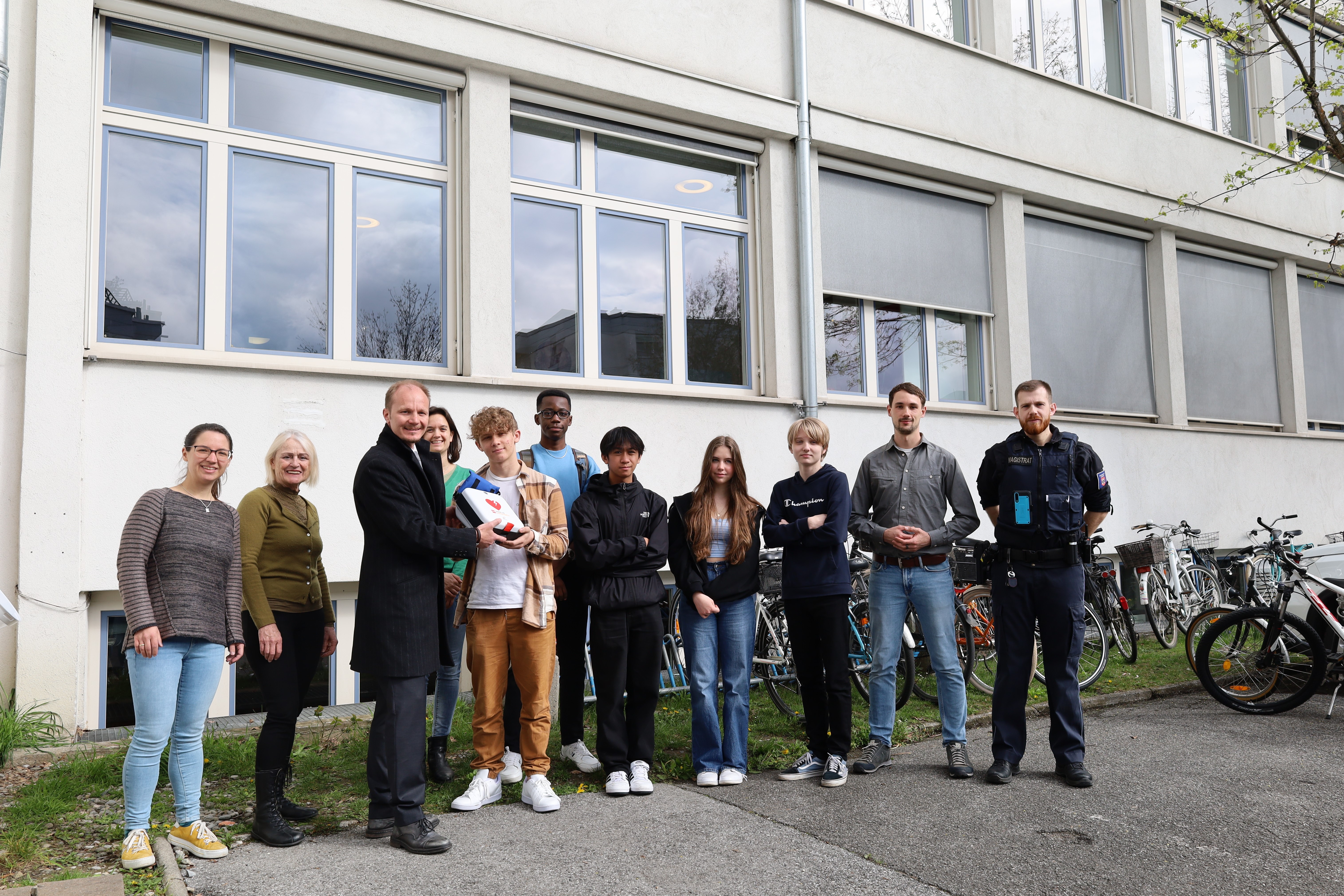 Wenn in einem medizinischen Notfall jede Sekunde zählt, sollte bestenfalls ein Defi nicht weit sein. Im Stadtgebiet gibt es derzeit mehr als 60 Defibrillatoren, die in der Öffentlichkeit gut sichtbar für den Notfall bereitstehen. Einer davon befindet sich ab sofort im Hof des Reithmann-Gymnasiums (Reichenau). Zusätzlich verfügt ein fünfköpfiges SchülerInnenteam über eine spezielle Erste-Hilfe-Ausbildung für Notfälle in der Schule. Bei der Übergabe des Gerätes am 17. April: Direktorin Maria Seiwald (2. v.l.), Vizebürgermeister Johannes Anzengruber (3. v.l.), Christian Schlögl (MÜG, 1. v.r.) und die LehrerInnen bzw. AusbildnerInnen (v.l.) Christina Volderauer, Julia Nagy und Christoph Moser - gemeinsam für eine herzsichere Stadt.