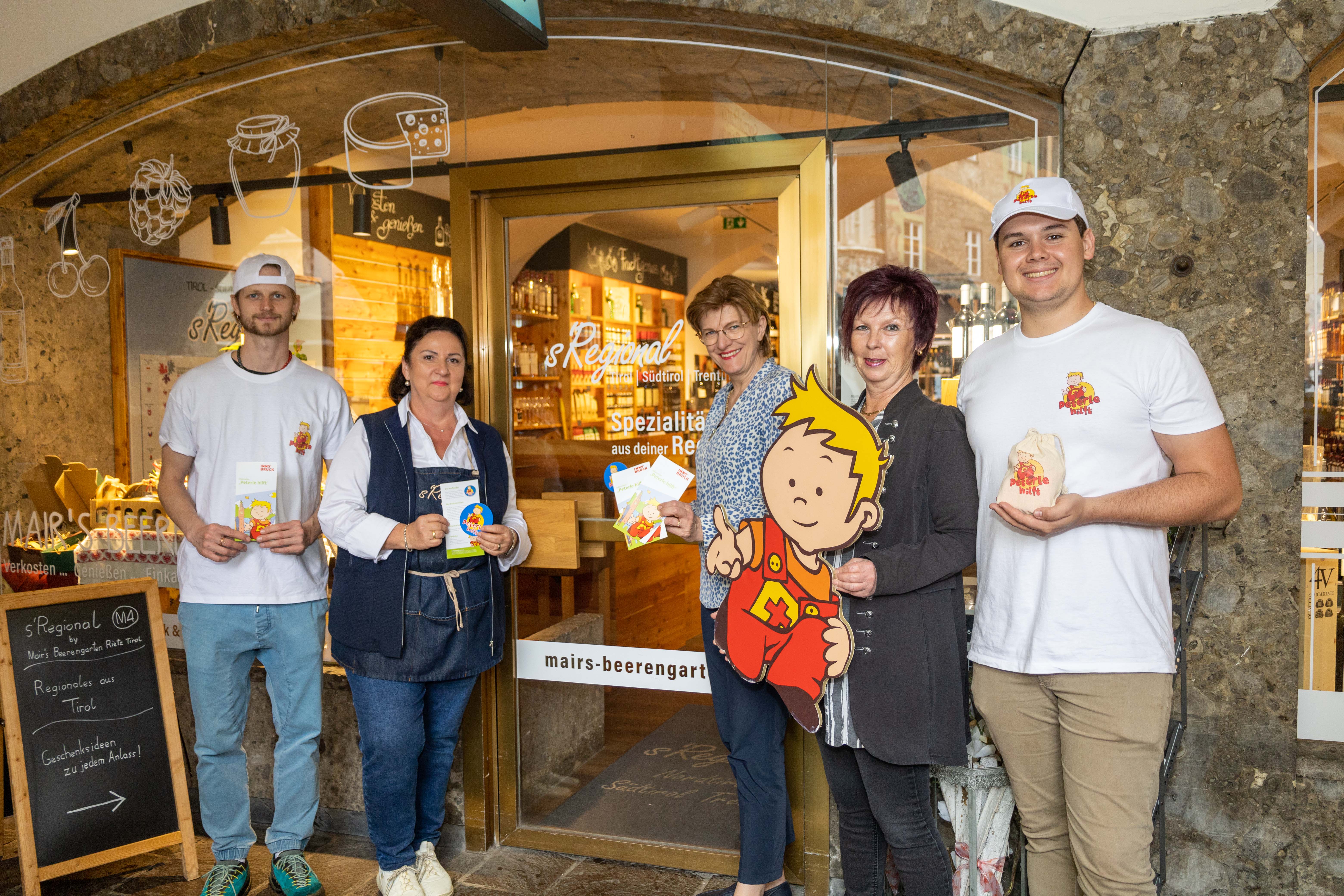 Der Tiroler Spezialitätenladen in der Innsbrucker Altstadt „s`Regional by Mairs Beerengarten“ ist Partner des „Peterle-hilft“-Projektes. Darüber freuen sich (v.l.) Peterle-hilft“-Teammitglied Tobias, Christine Wieser vom s`Regional by Mairs Beerengarten, Stadträtin Christine Oppitz-Plörer, Referatsleiterin für Frauen und Generationen Uschi Klee und Teammitglied Gregor.