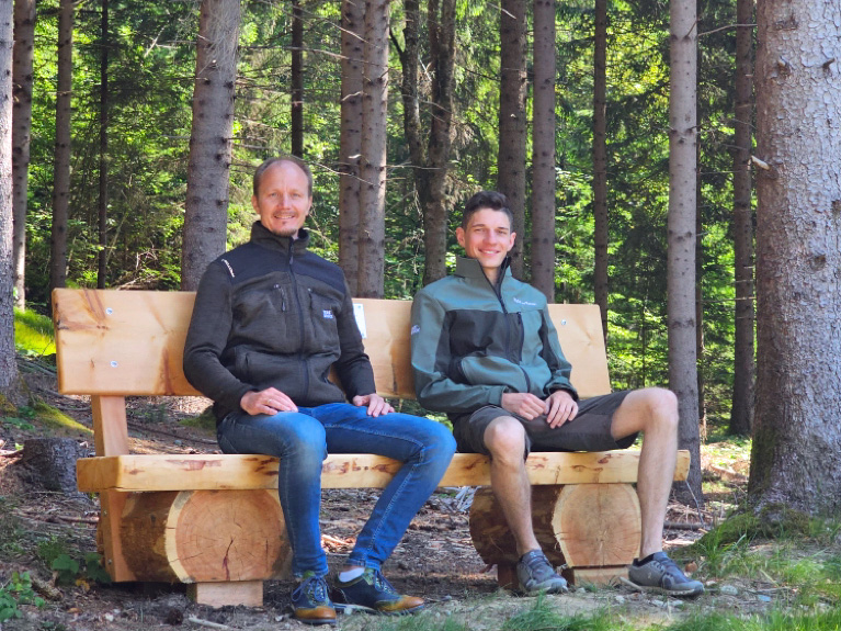 Vizebürgermeister Johannes Anzengruber (l.) und Referatlseiter Florian Jäger (r.) auf der neuen Zirben-Sitzbank am Gramartboden.