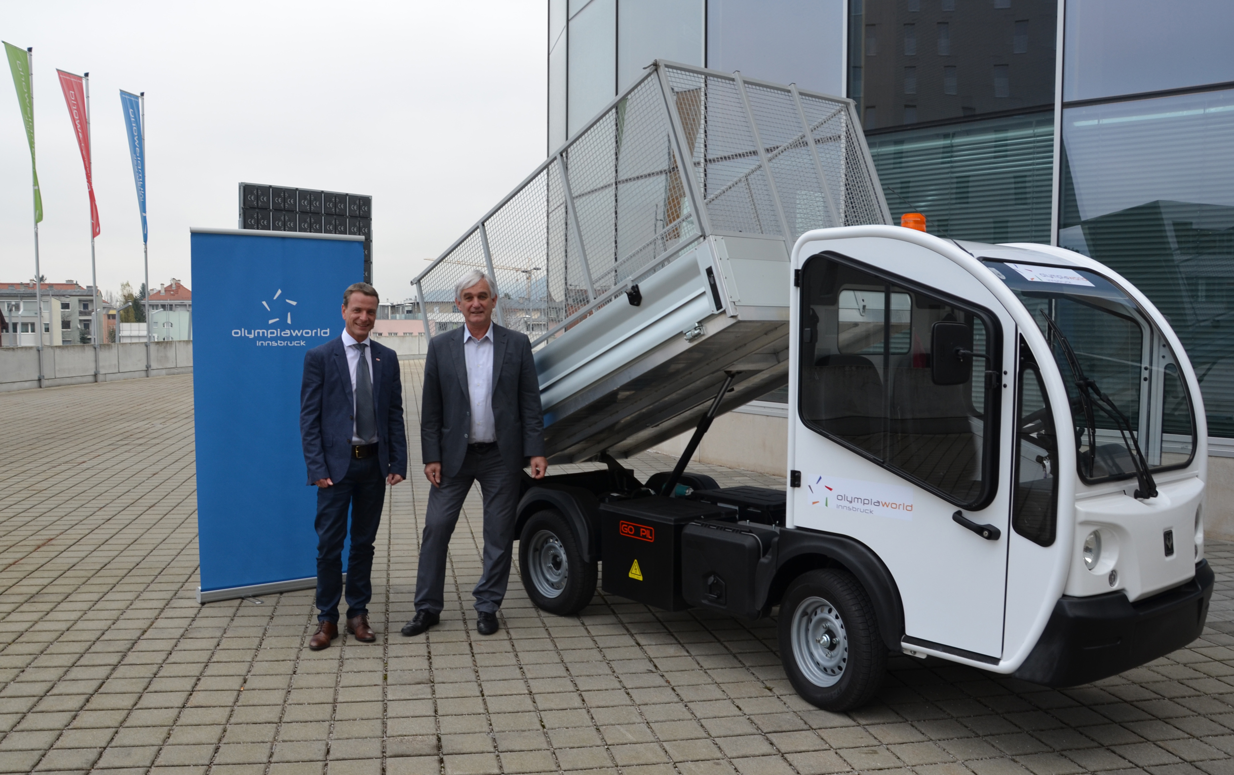 Vizebürgermeister Christoph Kaufmann und Olympiaworld-Geschäftsführer Dr. Michael Bielowski präsentieren das neue Elektro-Fahrzeug, das ab sofort auf dem Olympiaworld-Gelände im Einsatz ist.