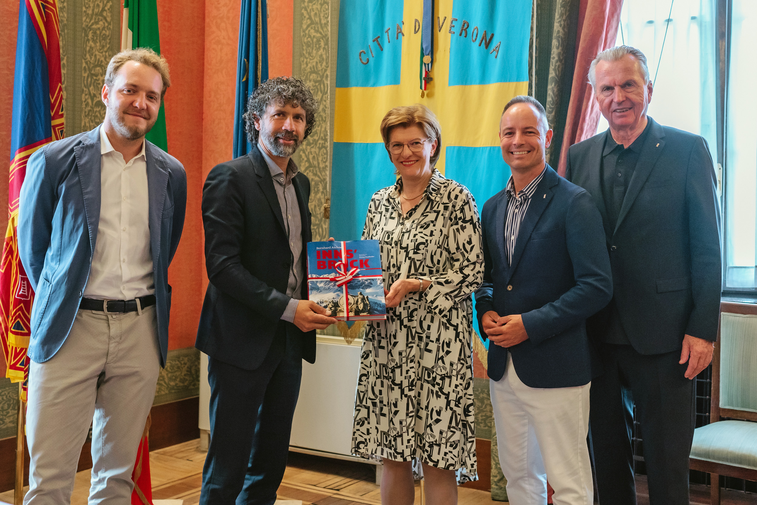 Stadträtin Christine Oppitz-Plörer, Vizebürgermeister Markus Lassenberger (2. v.r.) und Stadtrat Rudi Federspiel (r.) überbrachten eine digitale Einladung für einen Innsbruck-Besuch im Herbst an Bürgermeister Damiano Tommasi (2. v.l.) und Gemeinderat Giacomo Conta (zuständig für europäische Agenden).
