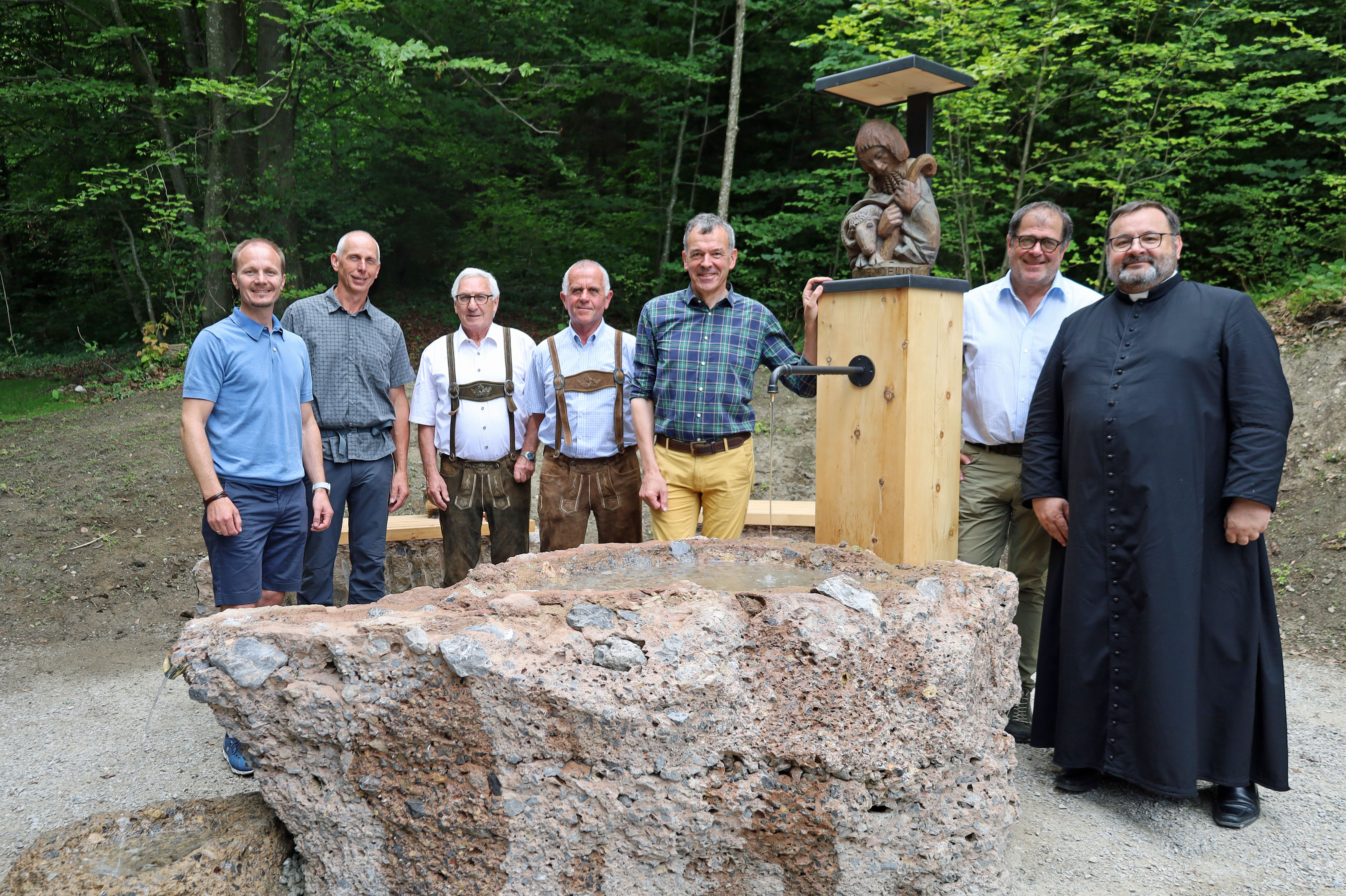 Bürgermeister Georg Willi (3.v.r), Vizebürgermeister Johannes Anzengruber (l.), Amtsvorstand Andreas Wildauer (Wald und Natur, 2.v.r.) Pfarrer Malek Ciesielski (Pfarre Hötting, r.), Pfarrökonom Josef Madersbacher (Pfarre Hötting, 4.v.l.), Siegfried Ploner (ploner.consult, 3.v.l.) und Forstunternehmer Manfred Leiter (2.v.l.) freuen sich über den neu errichteten Trinkwasserbrunnen am Höttinger Bild.