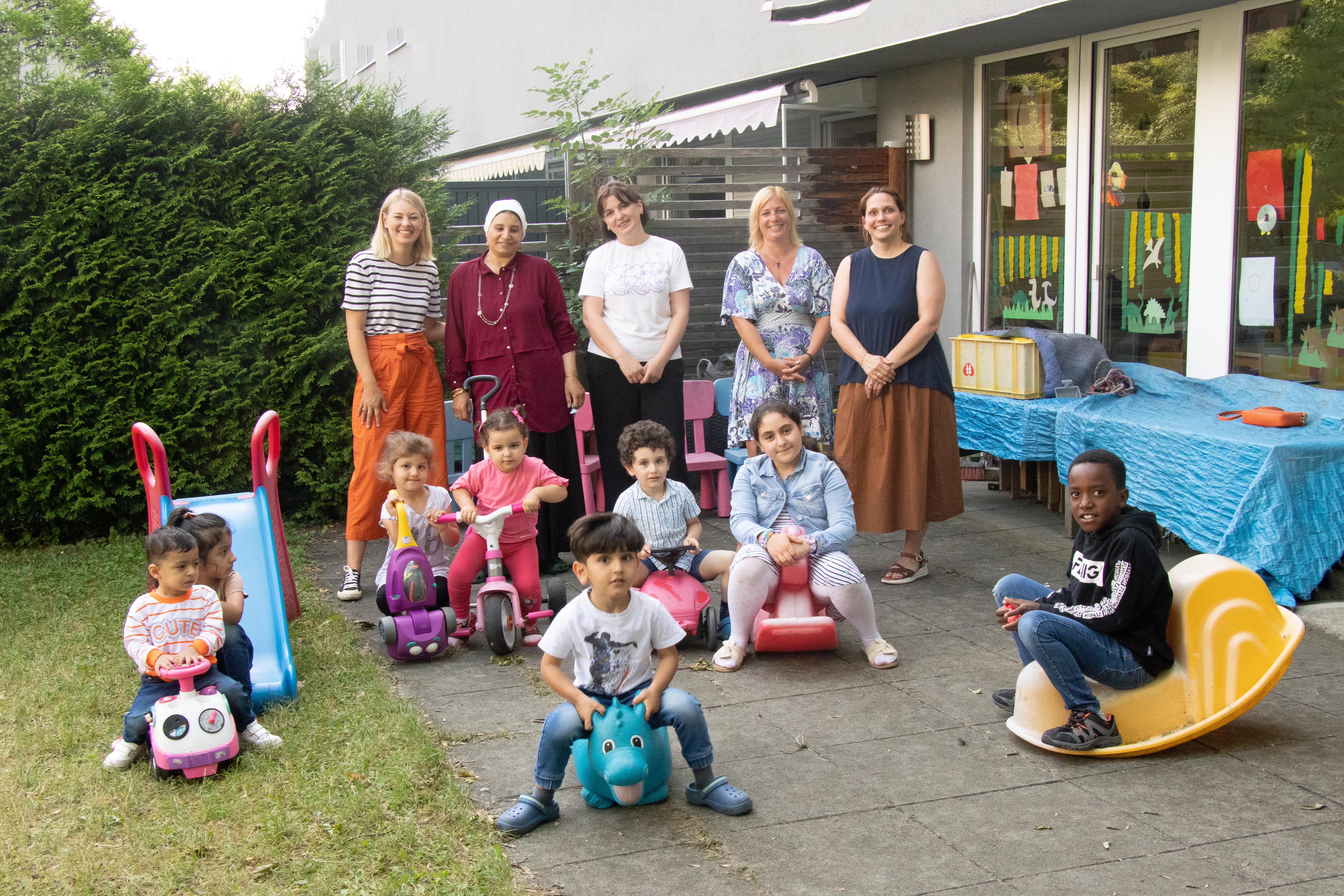 Bildungs- und Integrationsstadträtin Elisabeth Mayr (l.), BFI-Abteilungsleiterin Nora Loidl (2.v.r.) und Bereichsleiterin Romana Bichler (r.) von den Kinderfreunden freuen sich gemeinsam mit den betreuten Kindern sowie den MitarbeiterInnen der Kinderfreunde über das Betreuungsangebot während der BFI-Deutschkurse.