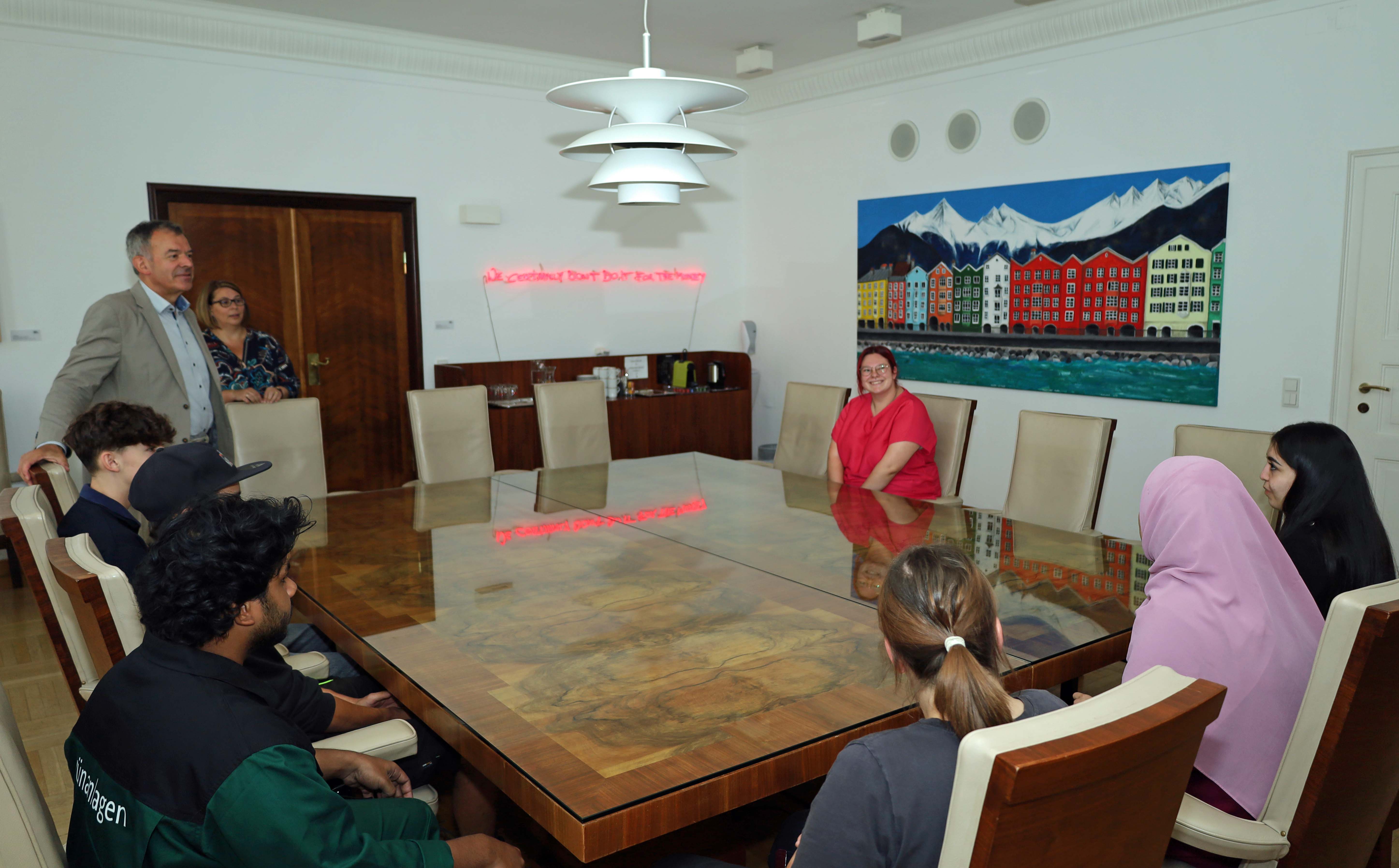 Innsbrucks Bürgermeister Georg Willi (l.), Amtsvorstand Wolfgang Hödl (Personalwesen, r.) und die städtische Lehrlingsbeauftragte Sabine Floßmann (5.v.l.) begrüßen die neuen Lehrlinge der Stadt Innsbruck im Stadtsenats-Sitzungszimmer im Rathaus.
