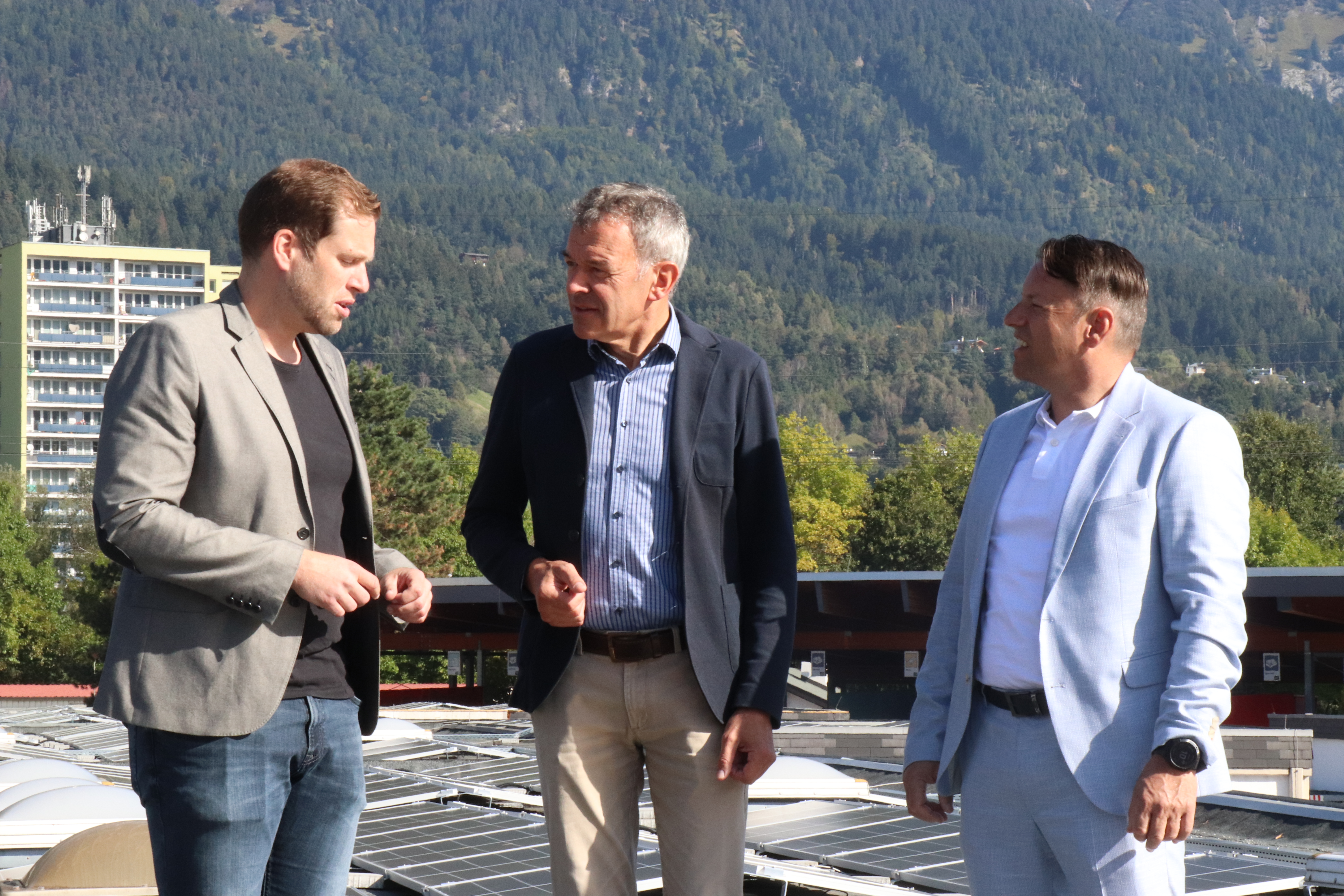Bürgermeister Georg Willi, IIG-Geschäftsführer Franz Danler (r.) und der technische Projektleiter Bernhard Pfeifer (l.) besichtigen die Photovoltaik-Anlage auf dem Dach des IIG-Gebäudes.