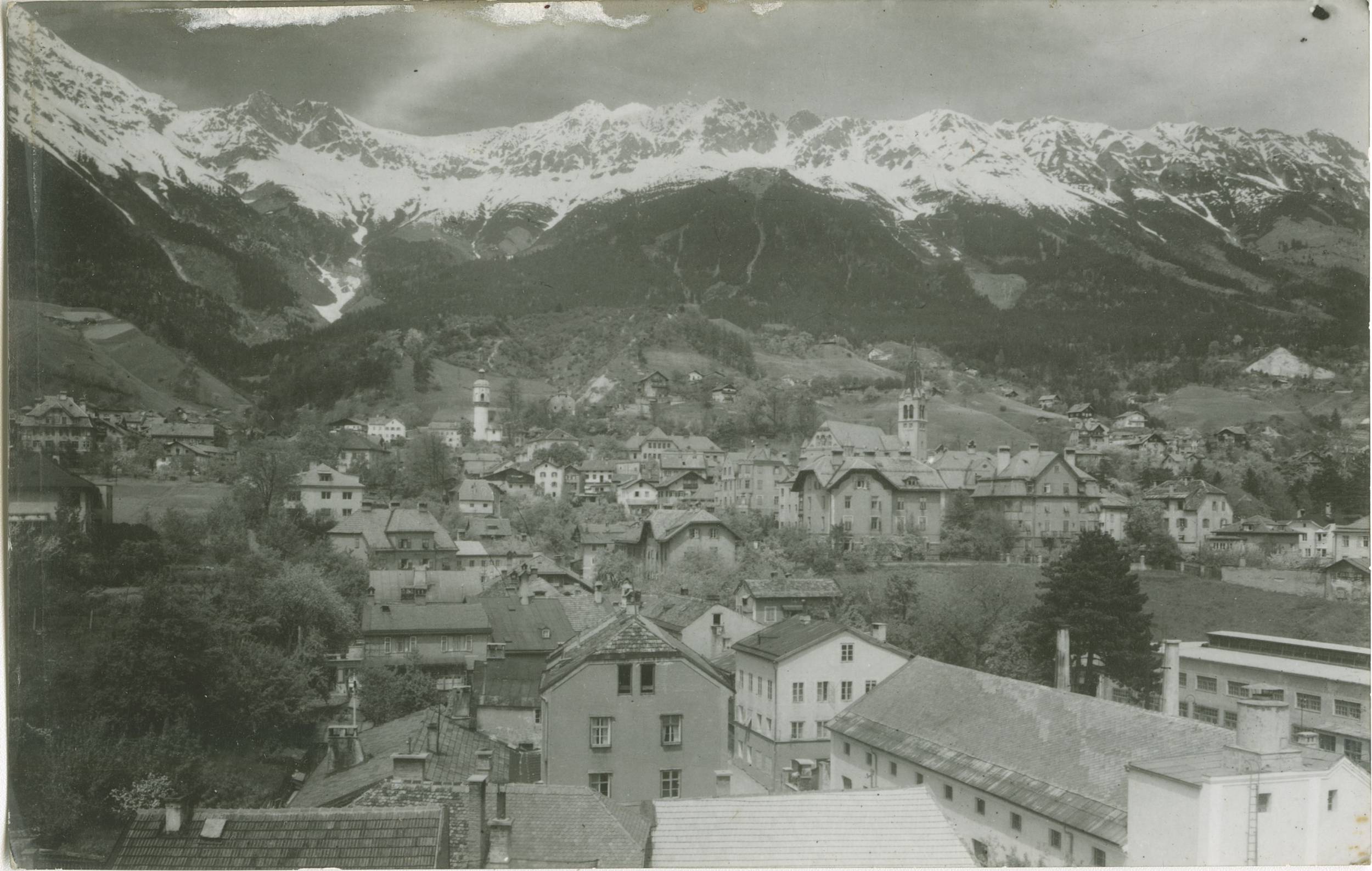 Blick auf das Kirschental im Stadtteil Mariahilf. Im Hintergrund die neue (rechts) und die alte (links) Höttinger Pfarrkirche, aufgenommen von Richard Müller um 1930.