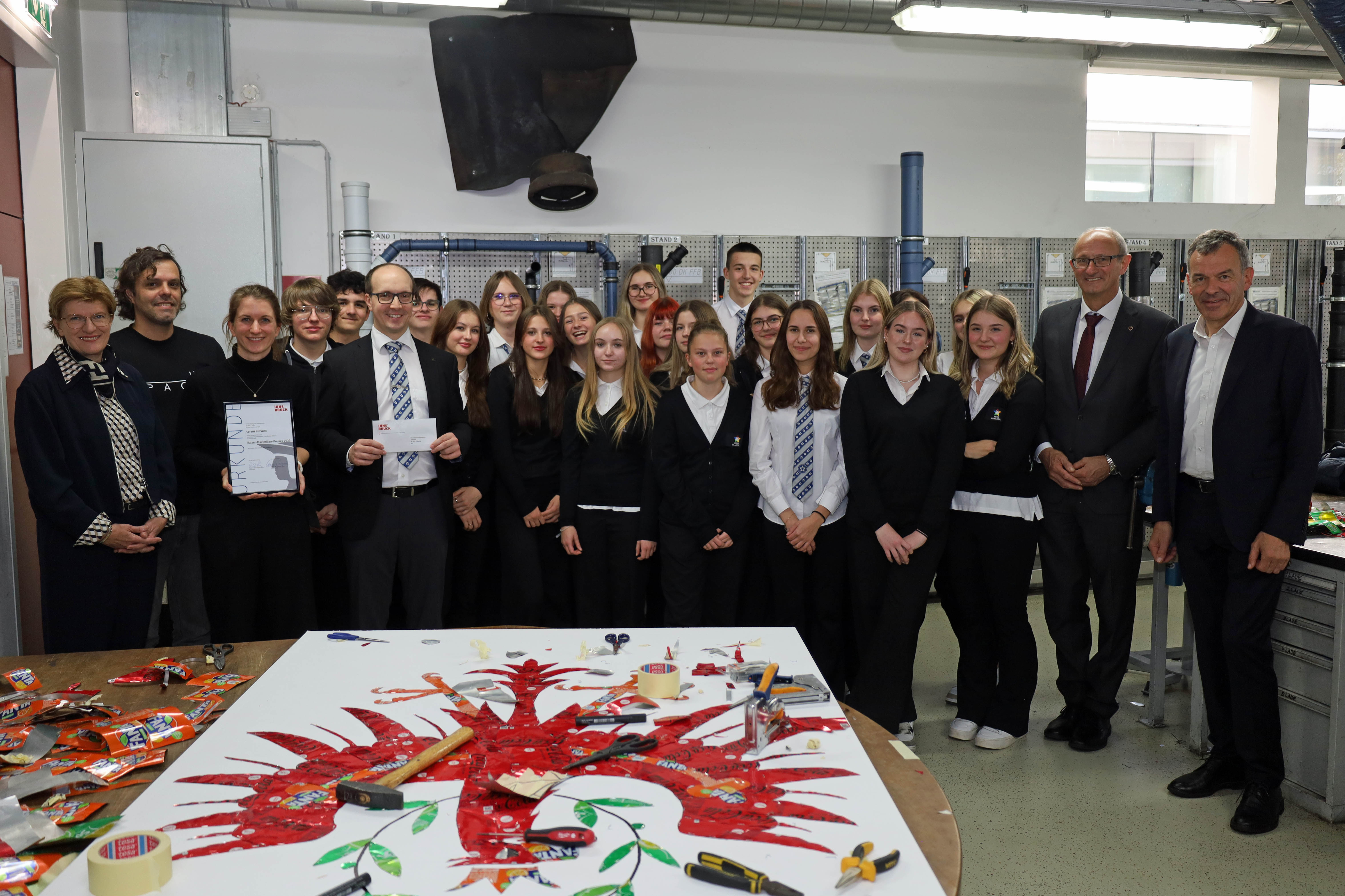 Landeshauptmann Anton Mattle (2.v.r.), Bürgermeister Georg Willi (r.), Stadträtin Christine Oppitz-Plörer (l.) und Kaiser-Maximilian-Preisträger José Rodrigues (2.v.l.) mit der 6G des BORG Zillertal, Gewinner der Kategorie „Oberstufe“, beim gemeinsamen Workshop in der TFBS Installations- und Blechtechnik.
