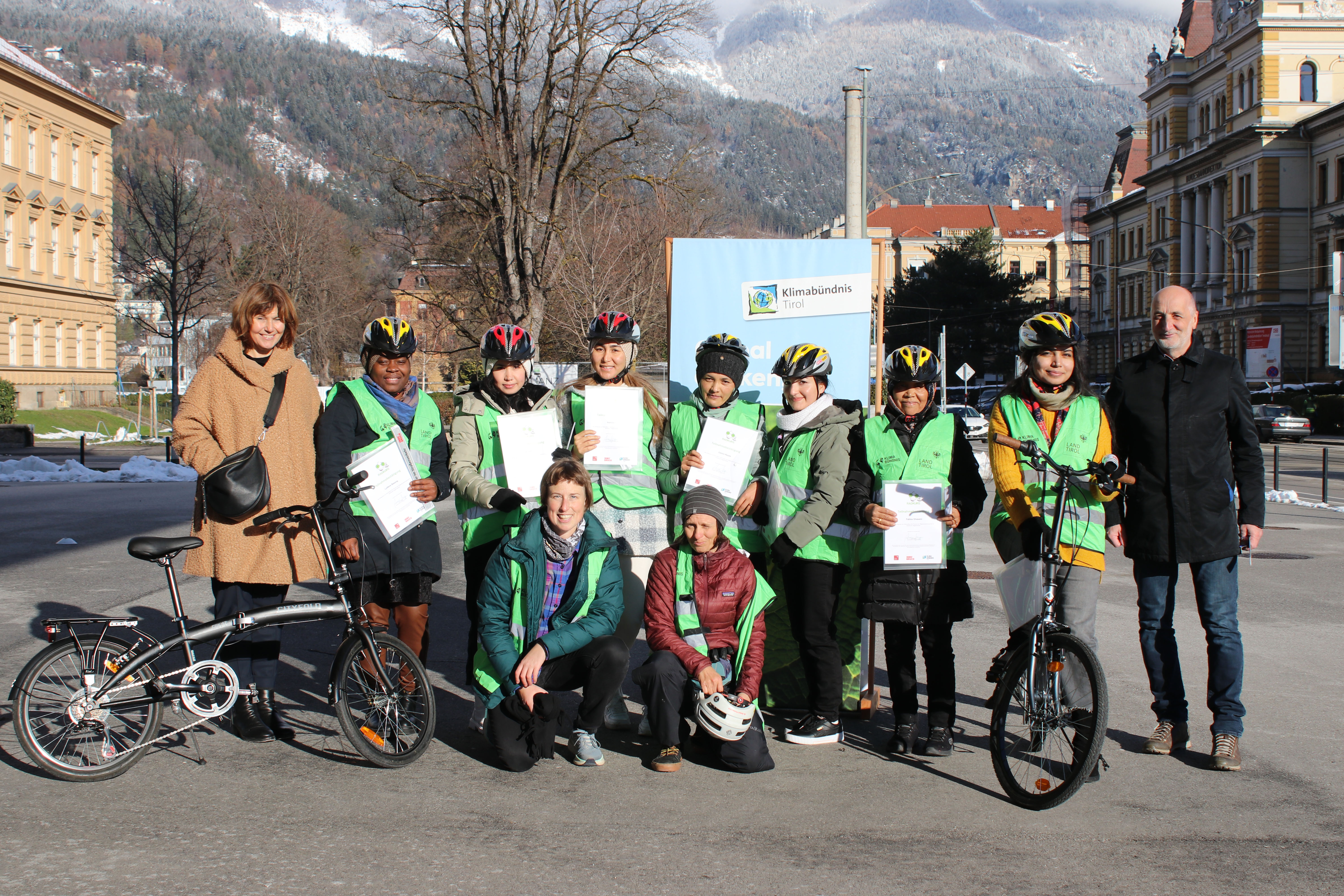 Bei der Übergabe der Radkurs-Teilnahmezertifikate vor der Messe Innsbruck:  Nicola Köfler (l., Integrationsstelle Stadt Innsbruck), Städtischer Fuß- und Radkoordinator Christian Schoder (r.) Simone Profus (Leitung Radkurse Klimabündnis Tirol, vorne links) und die Radkurs-Trainerin Isabella (vorne rechts) mit den Teilnehmerinnen.