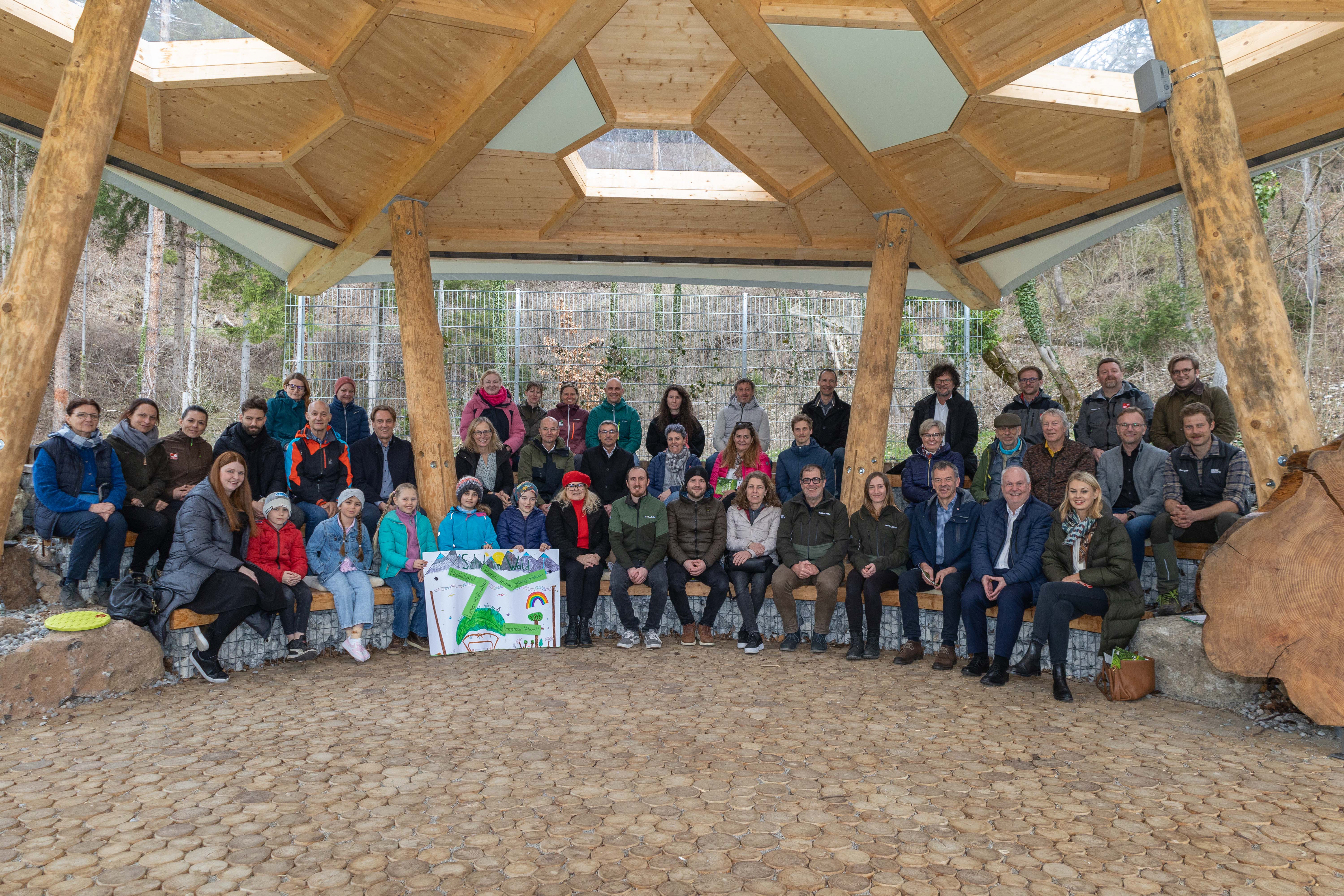 Erstes offizielles Klassenfoto: vorne: Bürgermeister Georg Willi (3. v. r.), Vizebürgermeister Andreas Wanker (2. v. r.), Stadträtin Elisabeth Mayr (r.), Amtsleiter Andreas Wildauer (5. v. r.), Mitarbeitende aus der städtischen Verwaltung und der Innsbrucker Immobiliengesellschaft, VertreterInnen der Partnerorganisationen von Land Tirol über Alpenzoo bis hin zu Naturpark Karwendel, viele Projektbegleitende und vor allem die anwesenden Schulkinder und Lehrpersonen freuten sich über die Eröffnung der städtischen Waldschule auf der Erlerwiese.