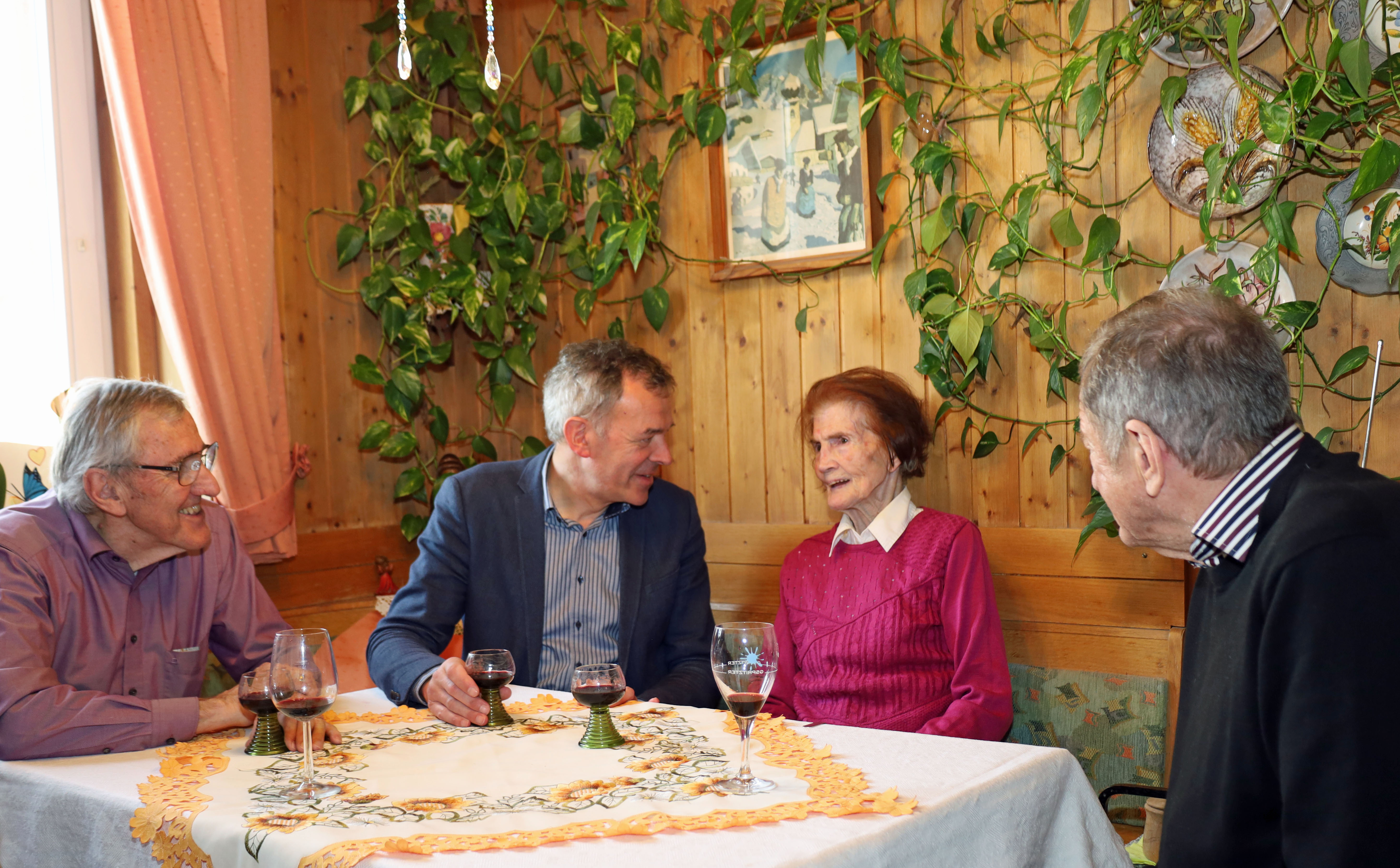 Maria Weger (2.v.r.) erzählt Bürgermeister Georg Willi (2.v.l.) bei der Feier im engen Familien- und Freundeskreis von ihrem Leben.