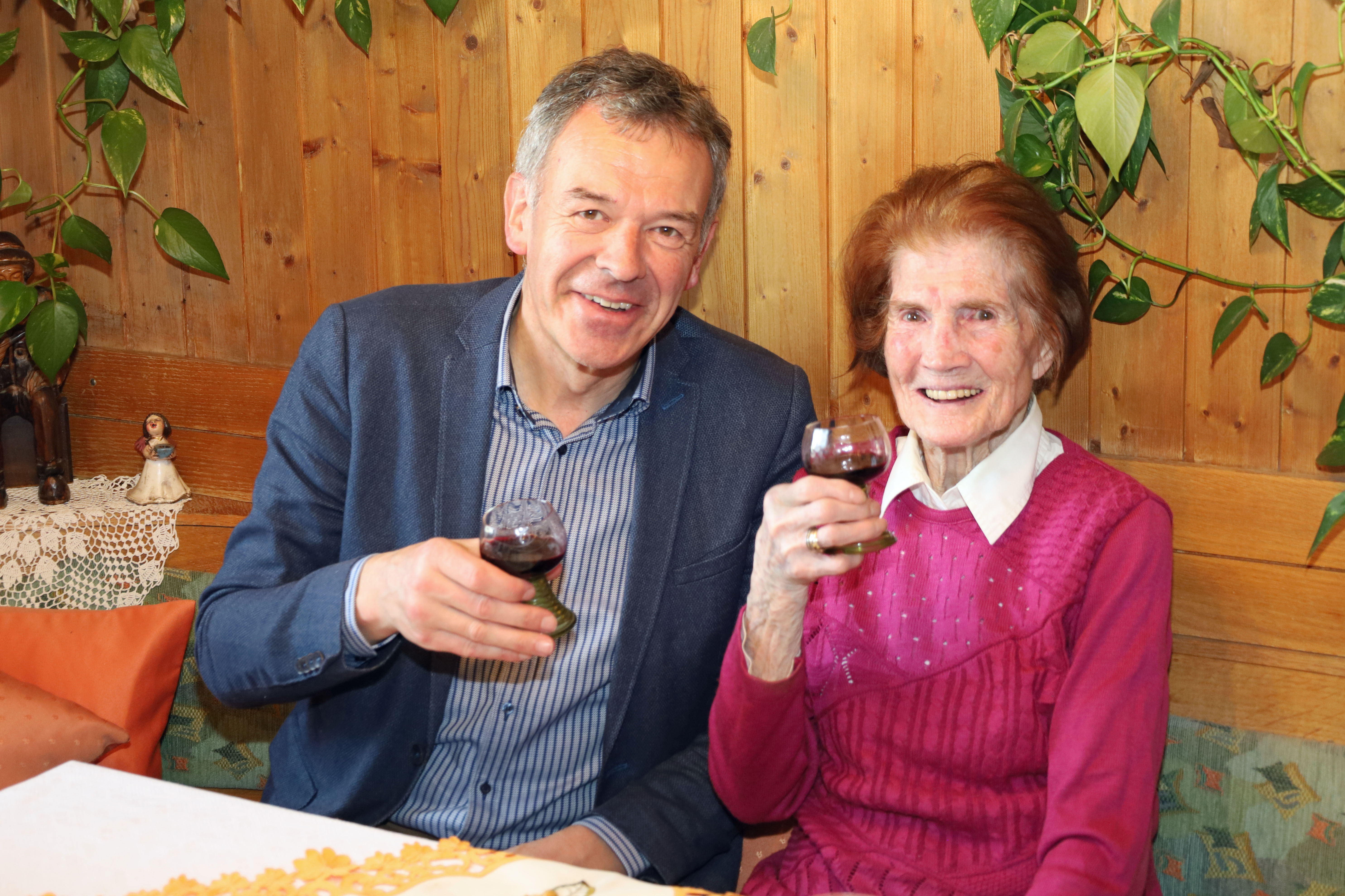 Zum „Hunderter“ stoßen Maria Weger (r.) und Bürgermeister Georg Willi mit Rotwein aus Südtirol an.