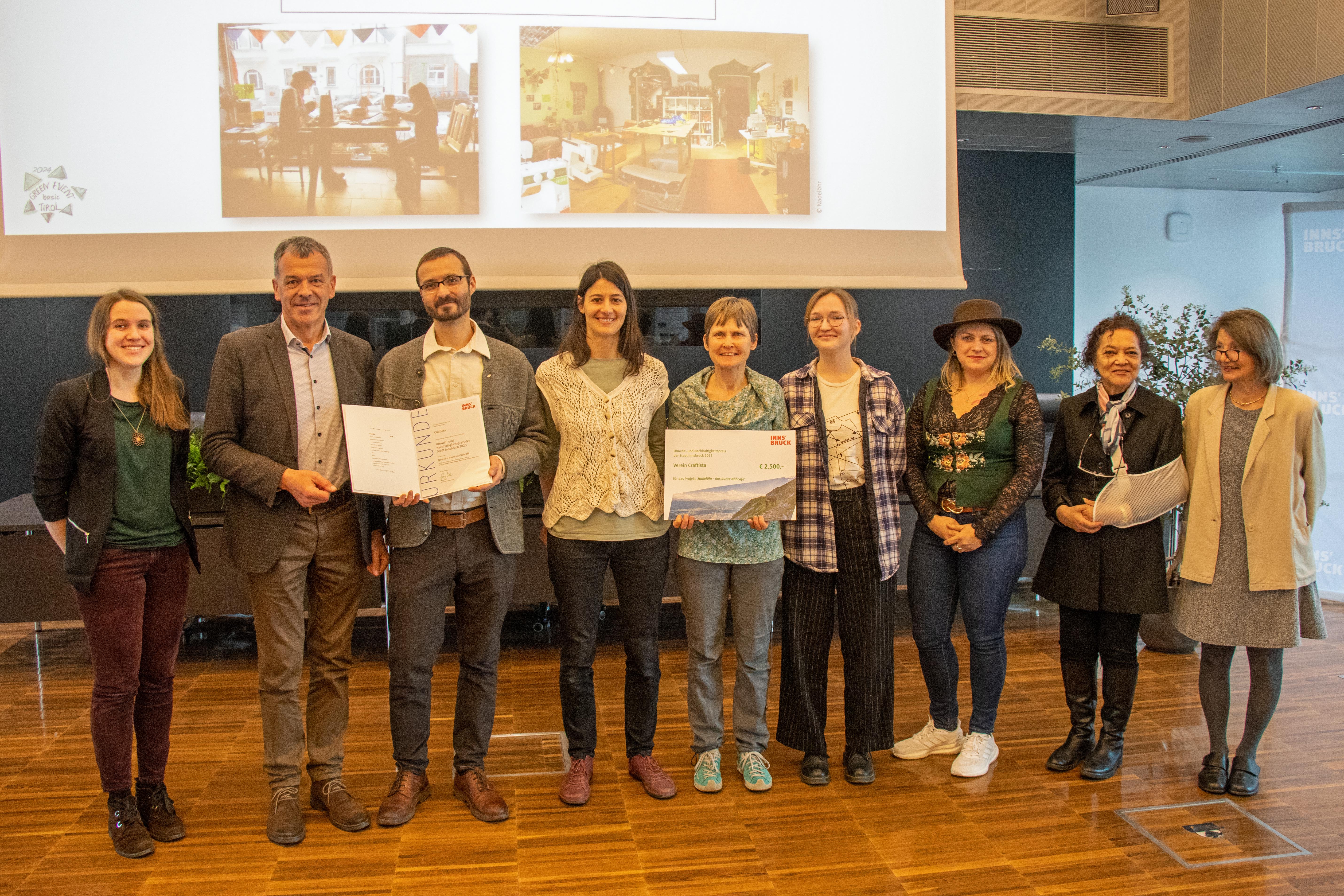 Bürgermeister Georg Willi (2.v.l.), Stadträtin Uschi Schwarzl (r.) und  Organisatorin Nadine Winzer (Klimaneutrale Stadt, l.) freuen sich mit den Mitgliedern des Vereins Craftista über die Auszeichnung für das Näh-Café "Nadelöhr".
