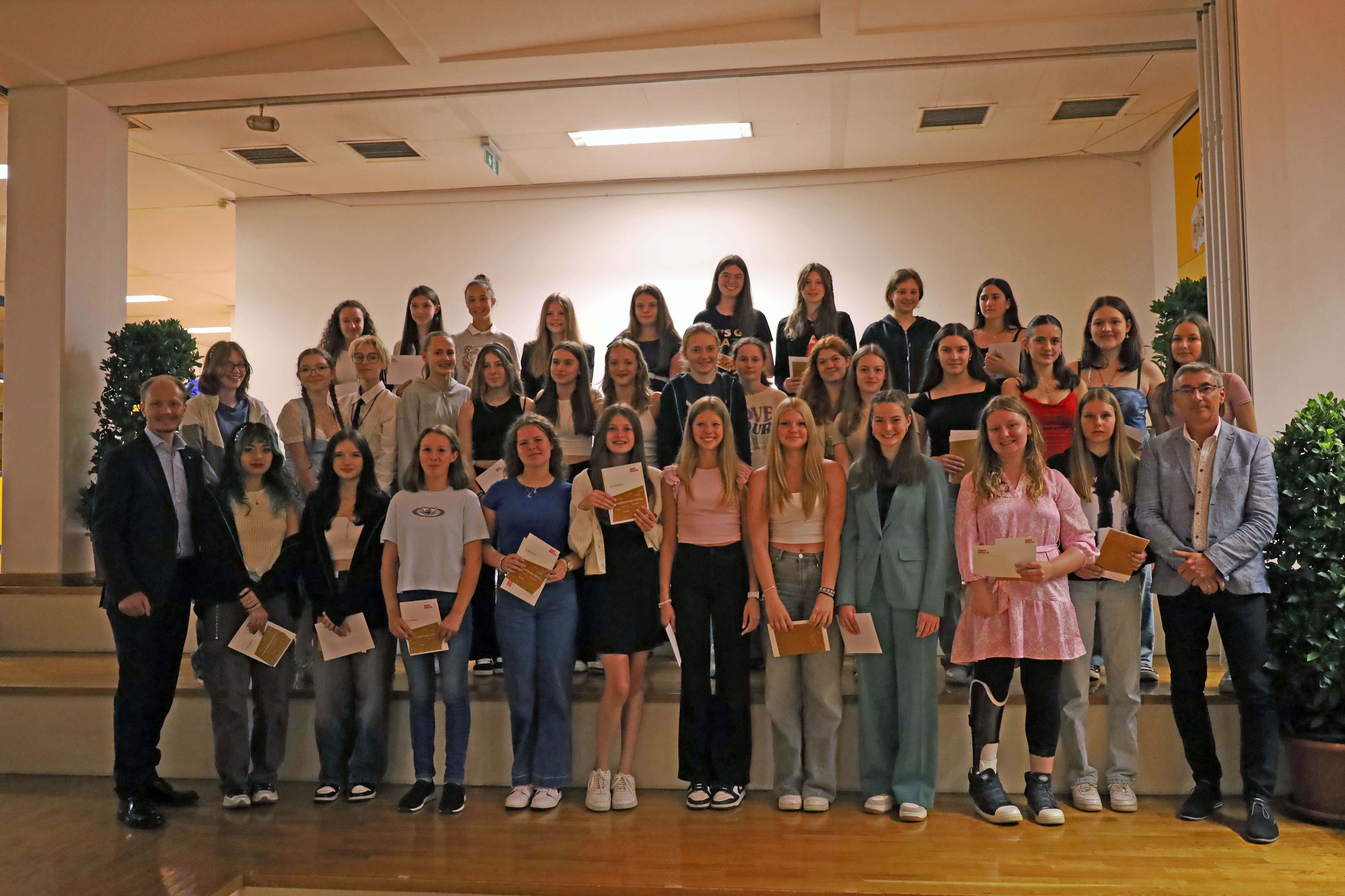 Bürgermeister Johannes Anzengruber (l.) und Schulqualitätsmanager Dietmar Meinschad (r.) mit den ausgezeichneten Schülerinnen der Mittelschule Kettenbrücke.