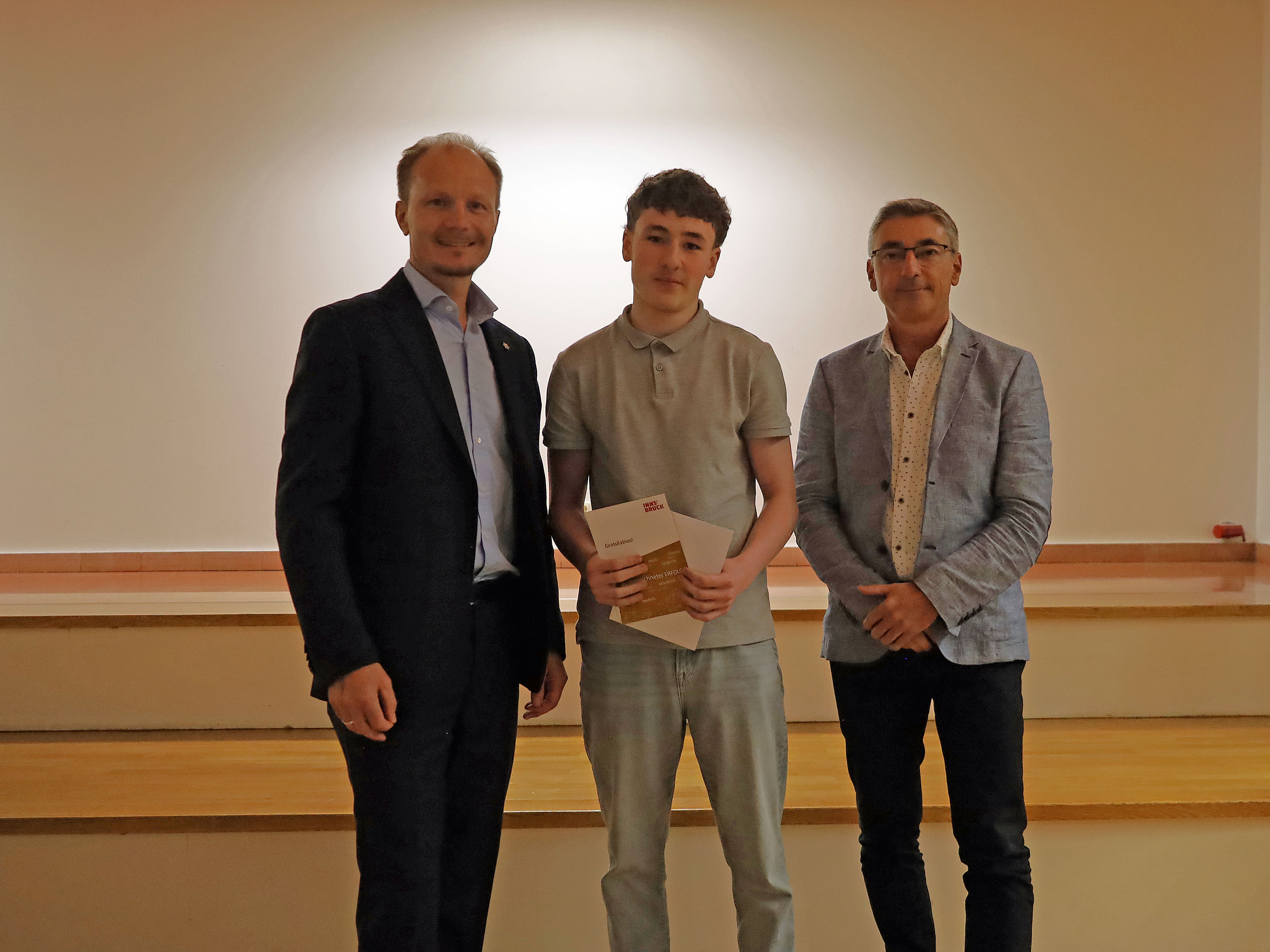 Bürgermeister Johannes Anzengruber (l.) und Schulqualitätsmanager Dietmar Meinschad (r.) mit dem ausgezeichneten Schüler der Mittelschule Pembaurstraße.