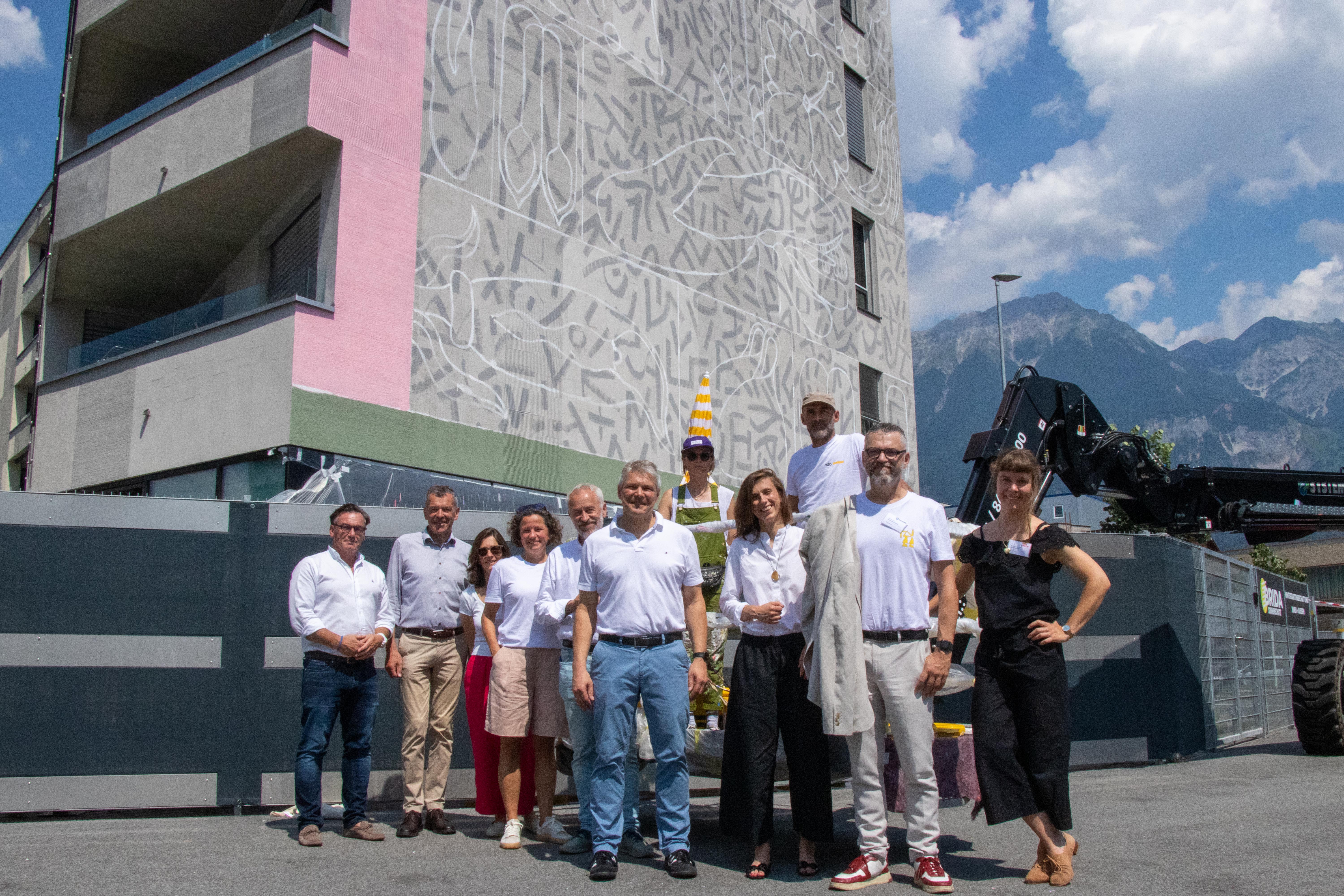 Verschafften sich einen Einblick der entstehenden Murals in der Andechsstraße (v.l.): NHT-Geschäftsführer Markus Pollo, Vizebürgermeister Georg Willi, Christina Alexandridis (Referat Kulturentwicklung und Förderungen), Geschäftsführerin Heike Kiesling (Innsbruck Marketing), Jes Lunde (Kulturstadtrat in Aalborg), Stefan Breiter (Bürgermeister Freiburg), Melanie Gandyra (Künstlerin Innsbruck), Maria Klaman (Stv. Stadtpräsidentin Krakau), Künstler NiKoDeM (Grenoble), Emmanuel Carroz (Vizebürgermeister Grenoble) und Gemeinderätin Aliena Knappe.