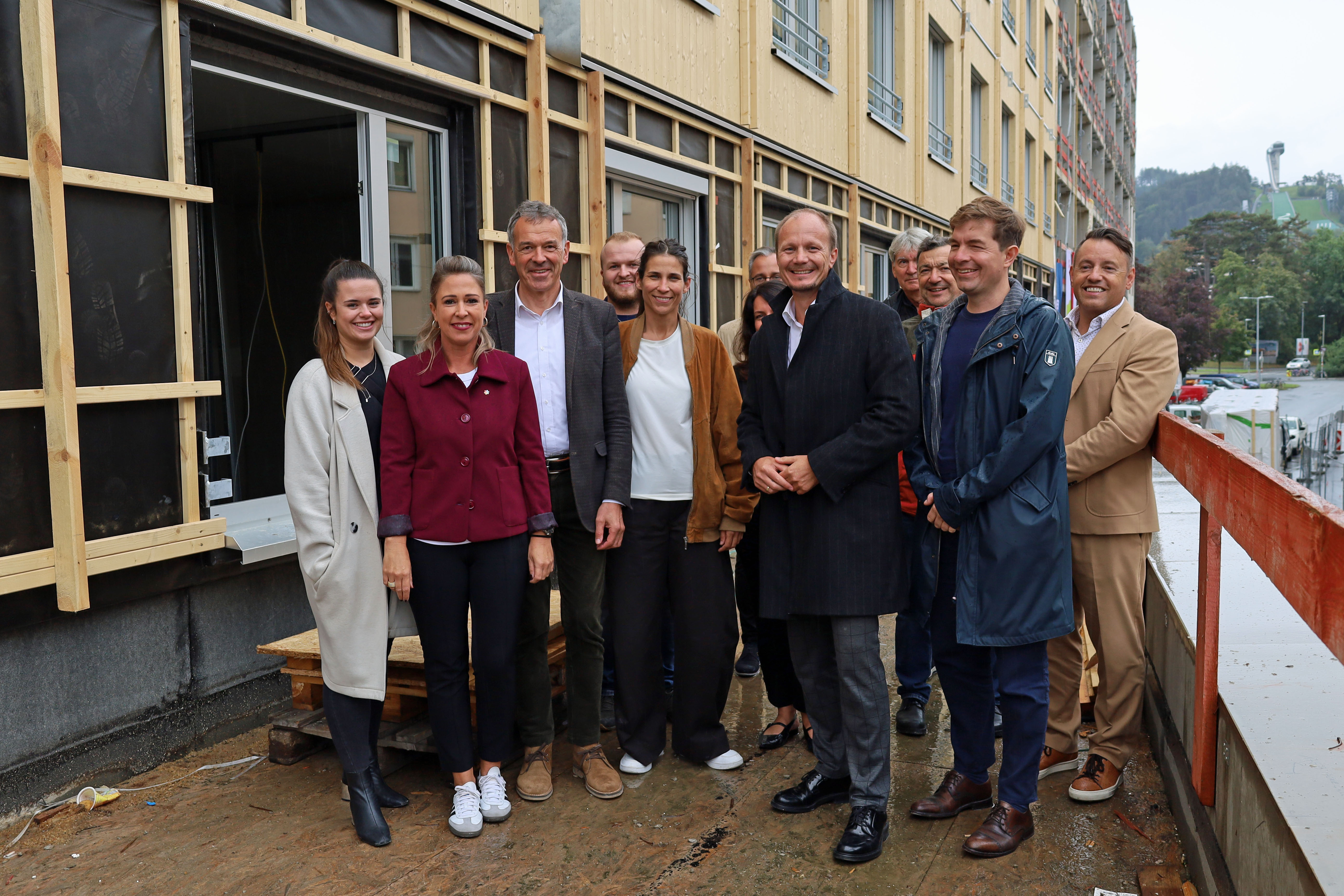 v.l.n.r.: Bauausschuss-Vorsitzende Julia Payr, Stadträtin Mariella Lutz, Vizebürgermeister Georg Willi, Stadträtin Janine Bex, Bürgermeister Johannes Anzengruber, Gemeinderat Mario Dallaserra, IIG-Geschäftsführer Franz Danler sowie (im Hintergrund) das ArchitektInnenduo Betina Hanel und Gerhard Manzl, Geschäftsführer Günther Jedliczka (OeAD student housing), Zoltan Gal von der Firma Kitzberger (Inneneinrichtung) und ein Vertreter der Baufirma Bodner.