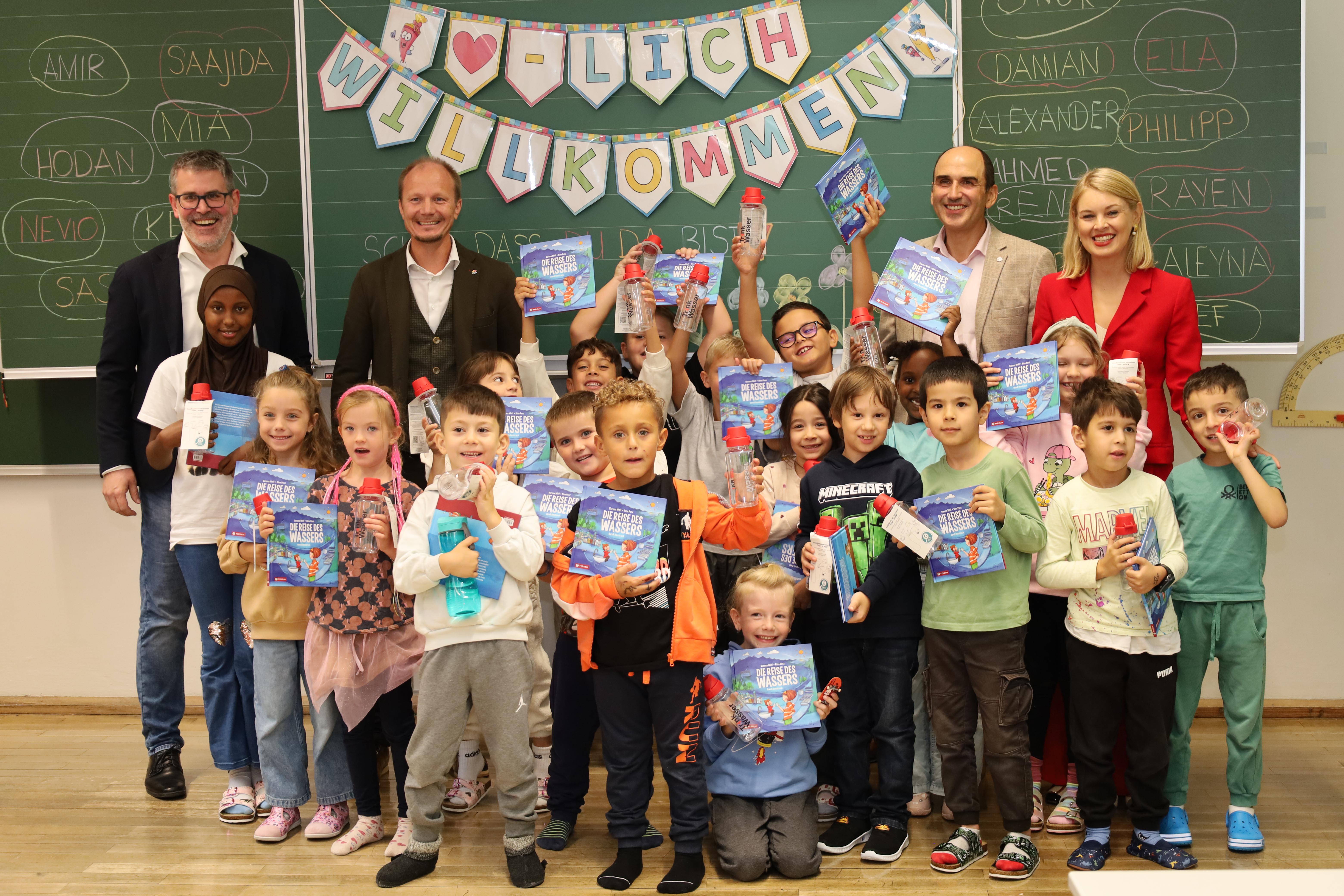 Freude in der Volksschule Pradl-Leitgeb II: Bürgermeister Johannes Anzengruber, Vizebürgermeisterin Elisabeth Mayr und Robert Gschleiner (IKB Geschäftsbereich Wasser) verteilten hochwertige Wasserflaschen als Geschenke an die ErstklasslerInnen (mit ihrem Direktor Christoph Trenker, 1.v.l.).