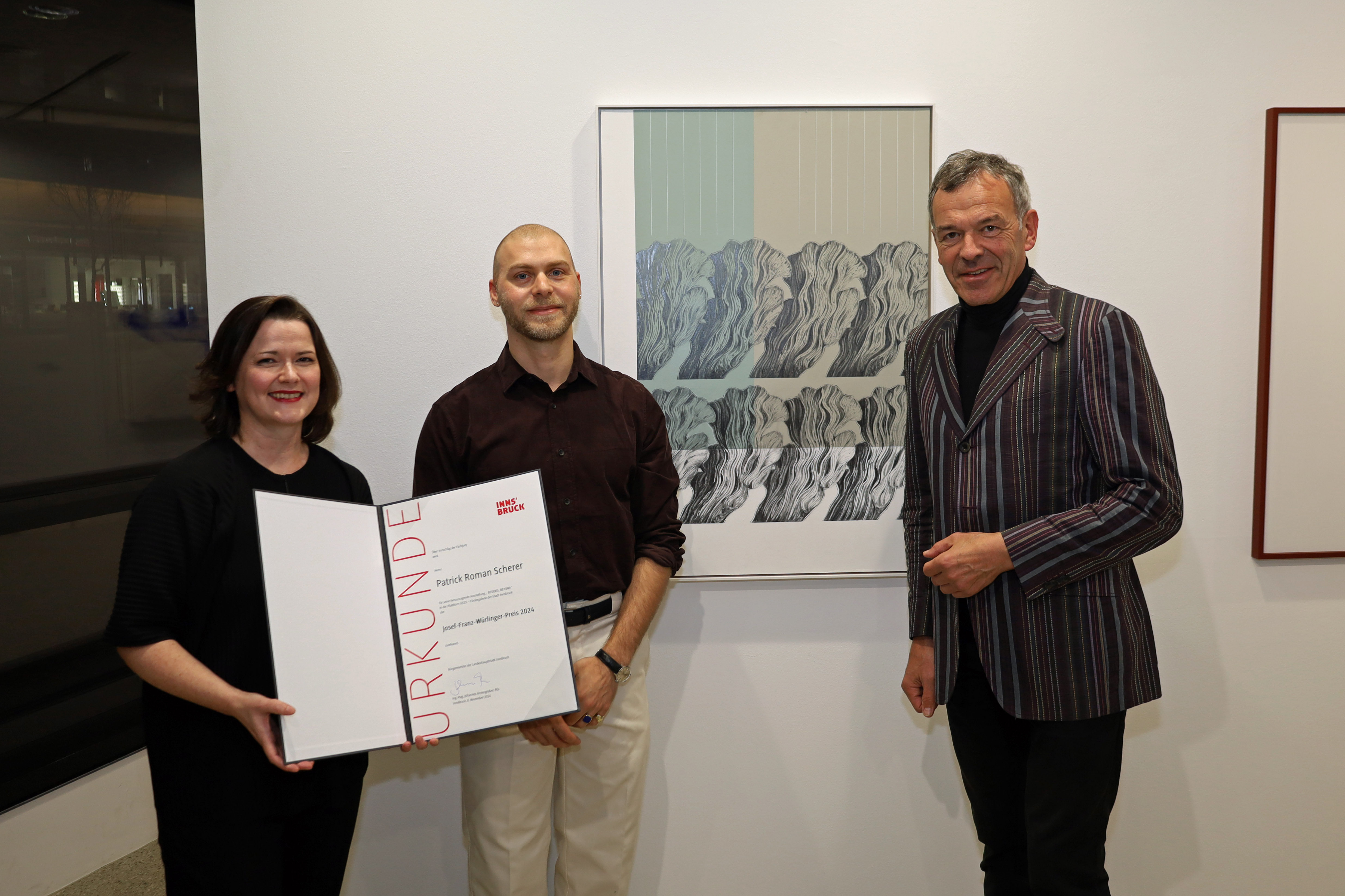 Patrick Roman Scherer (m.) erhält den Josef-Franz-Würlinger-Preis 2024 für seine Ausstellung „BESIDES, BEYOND“ in der Plattform 6020 – Vizebürgermeister Georg Willi (r.) und Galerieleiterin Natalie Pedevilla (l.) gratulieren dem Künstler zur Auszeichnung.