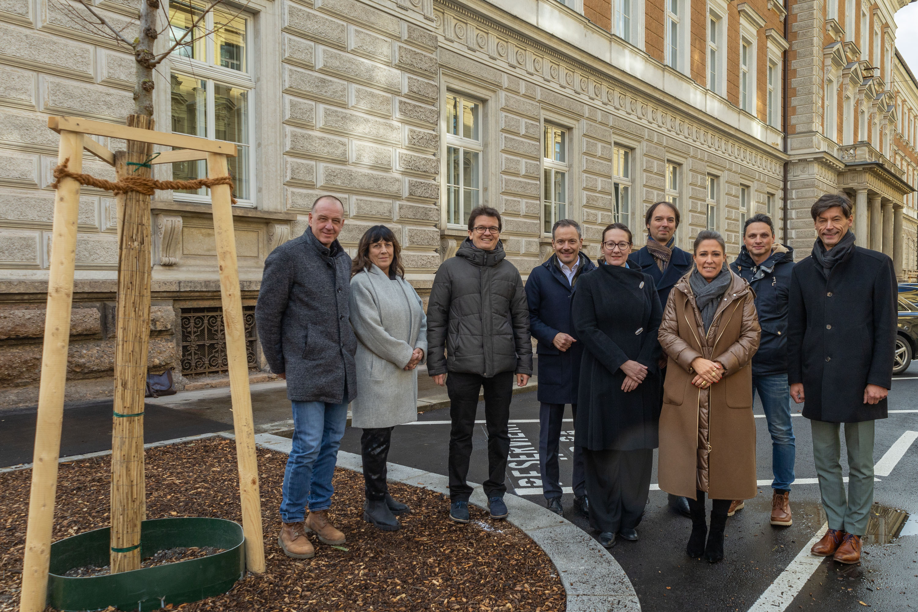 Gemeinsam für eine grünere Zukunft: v. l. n. r.: Robert Mair (Grünanlagen – Pflege und Service), Beate Abler (Richterin OLG), Referent Markus Pinter (Grünanlagen – Planung und Bau), Robert Wolf (ARE), Agata Bilinska (Oberstaatsanwältin), Holger Mangesius (Justizministerium), Stadträtin Mariella Lutz, Florian Wolf (Tiefbau – Planung) und OLG-Präsident Wigbert Zimmermann feiern die klimafitte Neugestaltung der Schmerlingstraße.