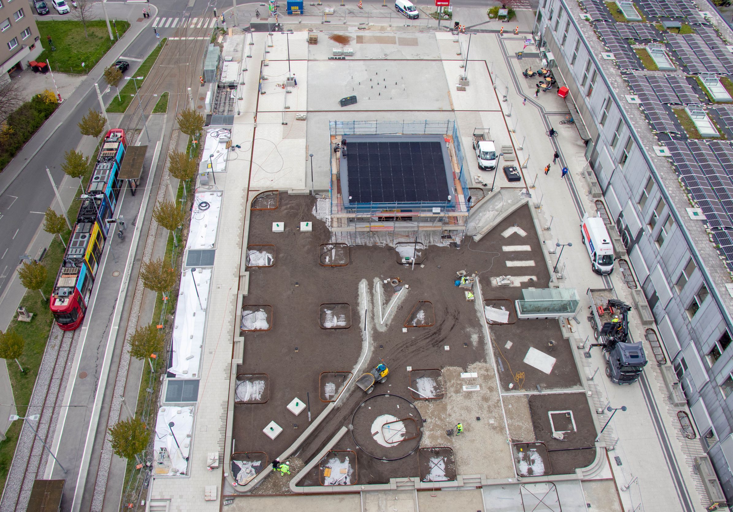 Für die begrünte Fläche im Herzen des Platzes wird derzeit fleißig Erde aufgeschüttet, auch der überdachte Bereich steht bereits.