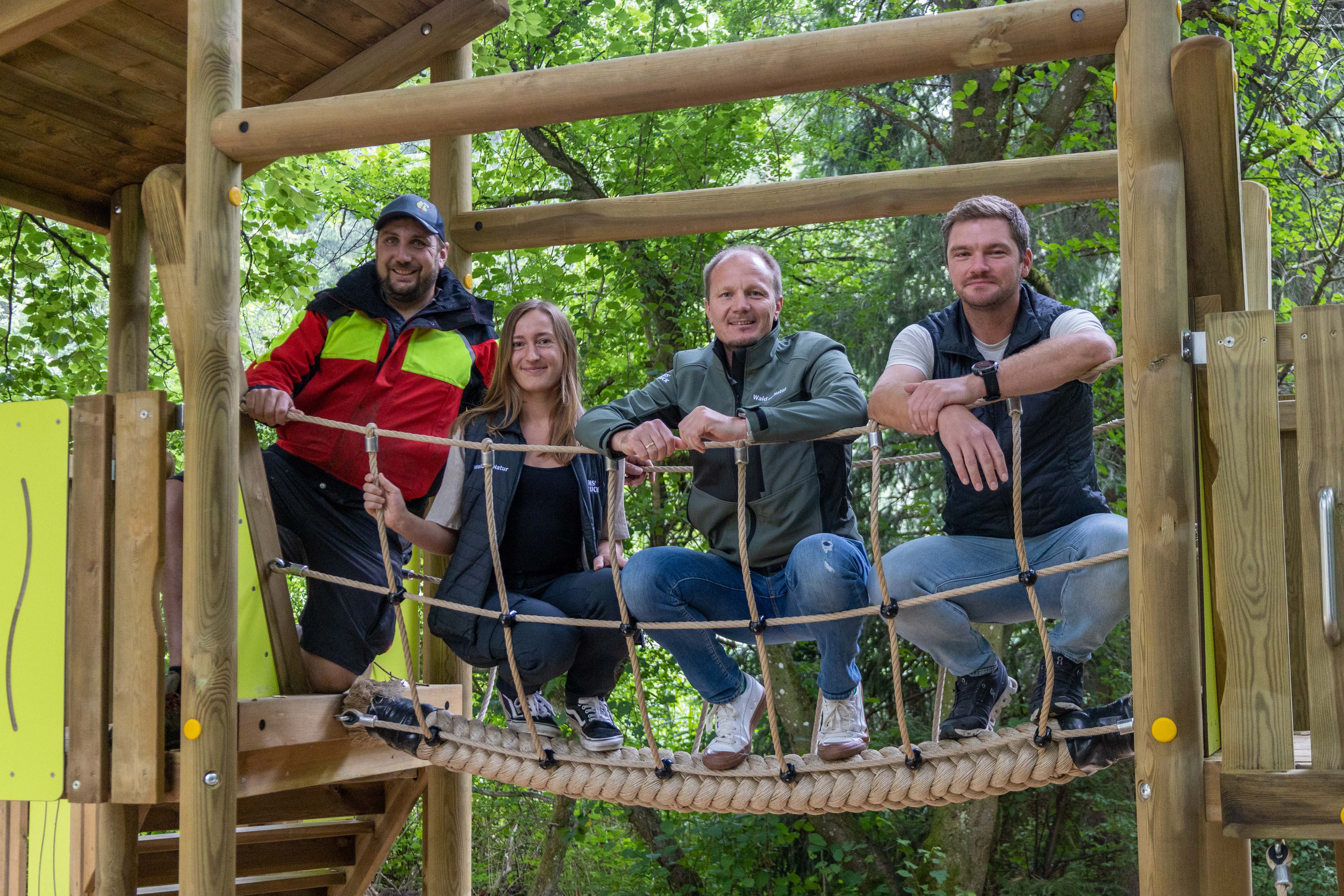 Bürgermeister Johannes Anzengruber, Amtsleiter Matthias Stang (r., Wald und Natur), Charlotte Eggert (Referat Natur und Erholung) sowie David Lukasser (l.) vom städtischen Forstbetrieb begutachten den neu gestalteten Spielbereich mit Kletterturm am Waldspielplatz Tantegert.