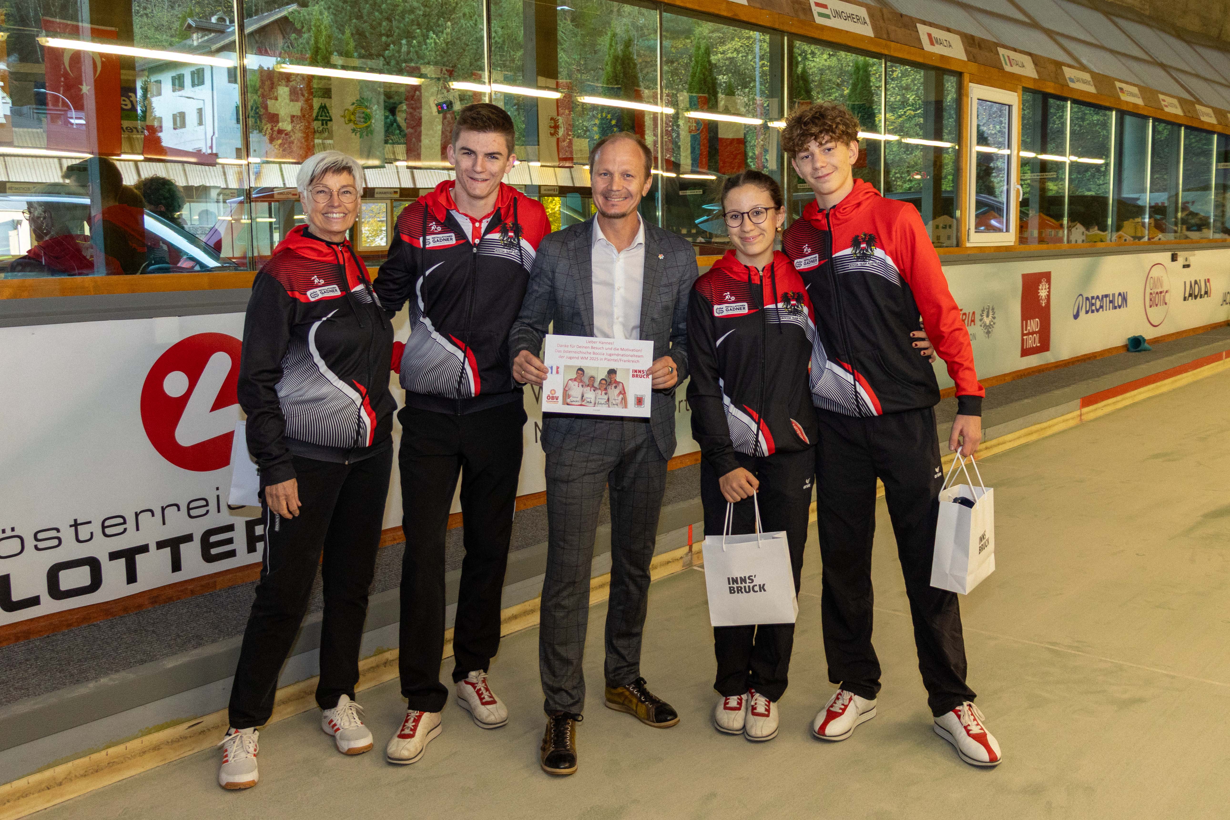 Innsbrucker Talente vertreten Österreich in Frankreich! Die Jugendabteilung des Boccia-Klubs ESK Tivoli nimmt an der Jugend-Weltmeisterschaft 2025 im französischen Plaintel teil. Bürgermeister Ing. Mag. Johannes Anzengruber, BSc verabschiedete die drei jungen AthletInnen und ihre Betreuerin persönlich auf dem Trainingsgelände des Vereins und überreichte Geschenke der Stadt Innsbruck. Beim Abschlusstraining probierte sich der Bürgermeister sogar selbst im Präzisionsschuss, bevor die Delegation gemeinsam mit ihrem Fanclub die rund 1.350 Kilometer lange Reise nach Frankreich antrat.