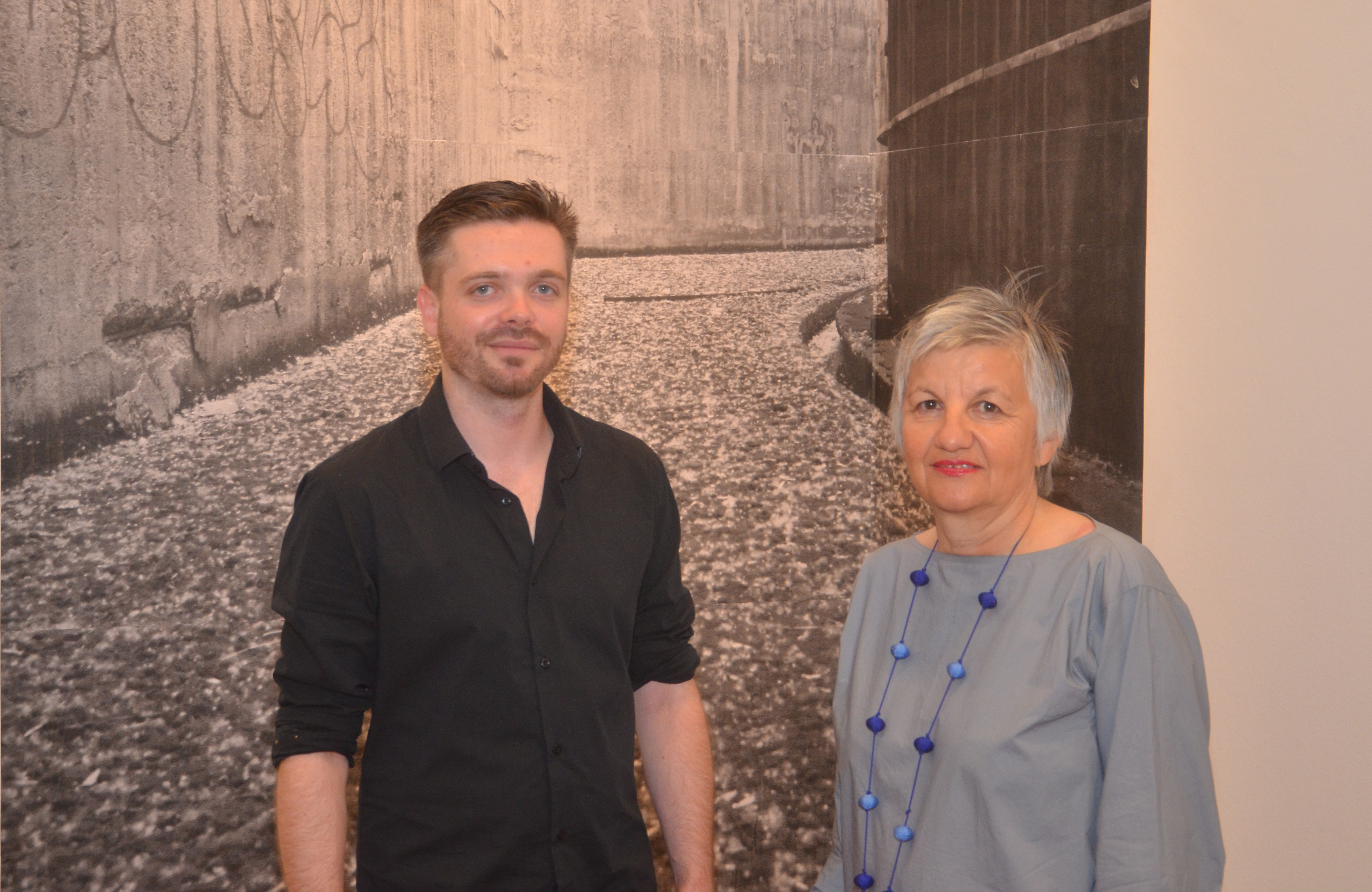 Fotograf Tillman Schneider gemeinsam mit Kathrin Mader-Walch (Stadt Innsbruck) vor einem der vergessenen Orte, die er aktuell in der Andechsgalerie ausstellt.