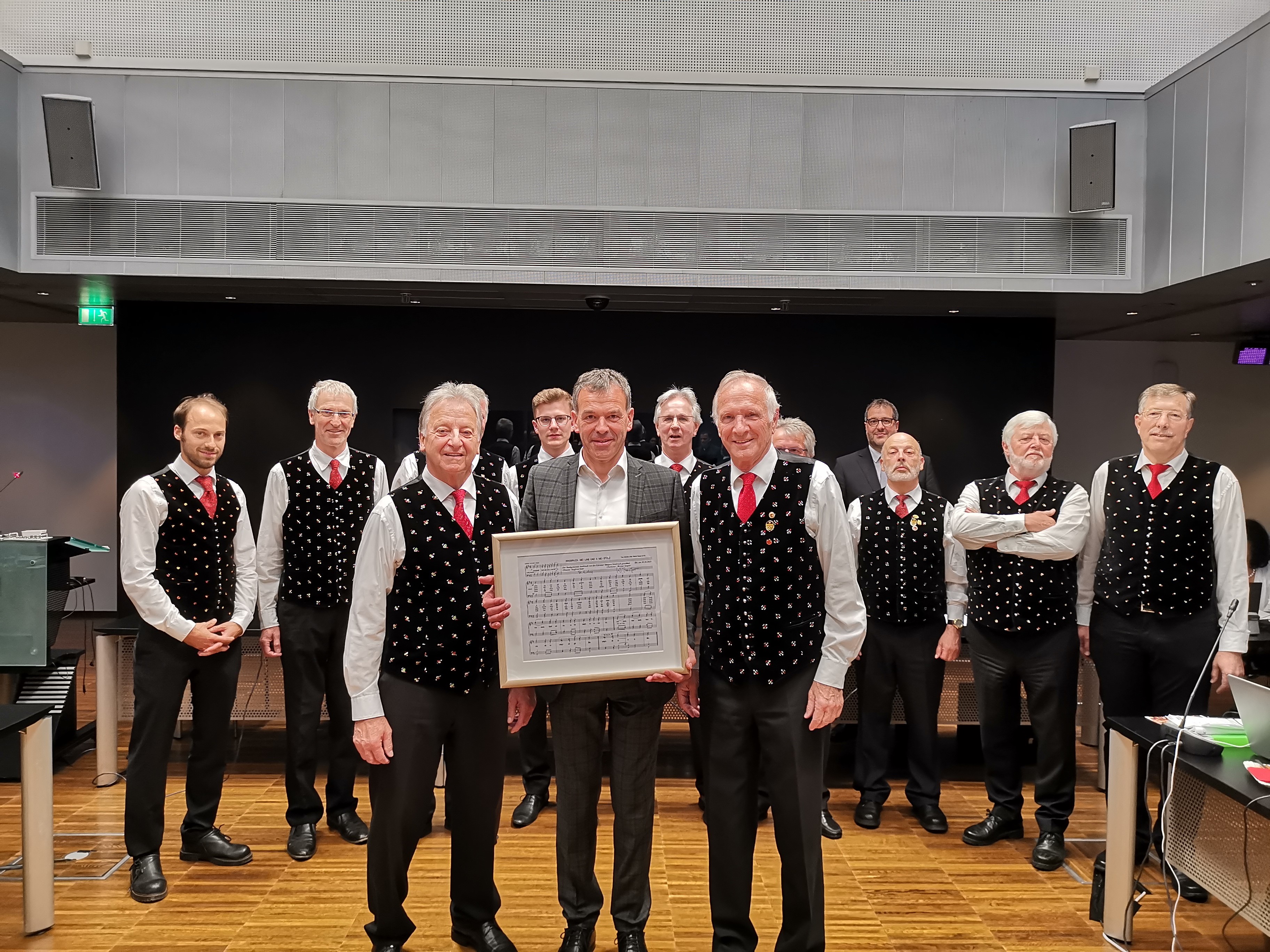 Der Gemeinderat, der am vergangenen Donnerstag tagte, erhielt eine musikalische Untermalung. Die Gesangsgruppe der "Kärntner Sänger Innsbruck" rund um Chorleiter Werner Sauper (vorne, r.) und Obmann Siegfried Eder (vorne, l.) präsentierten Bürgermeister Georg Willi und den Innsbrucker GemeinderätInnen ihre Gesangskünste und unter anderem das Lied „Innsbruck mei Liab und a mei Stolz“. Im Jahre 1901 gründeten in Innsbruck ansässige Kärntner den „Kärntner Unterstützungs- und Geselligkeitsverein Gemütlichkeit“ mit dem Zweck heimatliche Lieder, sowie gesellige Unterhaltungsabende zu pflegen und hilfsbedürftige Mitglieder zu unterstützen. Aus dieser Urzelle entwickelten sich unter verschiedensten Vereinsbezeichnungen und unter schwierigsten Bedingungen Gesangsgruppen mit bis zu 40 SängerInnen mit wechselvoller Vereinsgeschichte und entsprechenden Erfolgen.